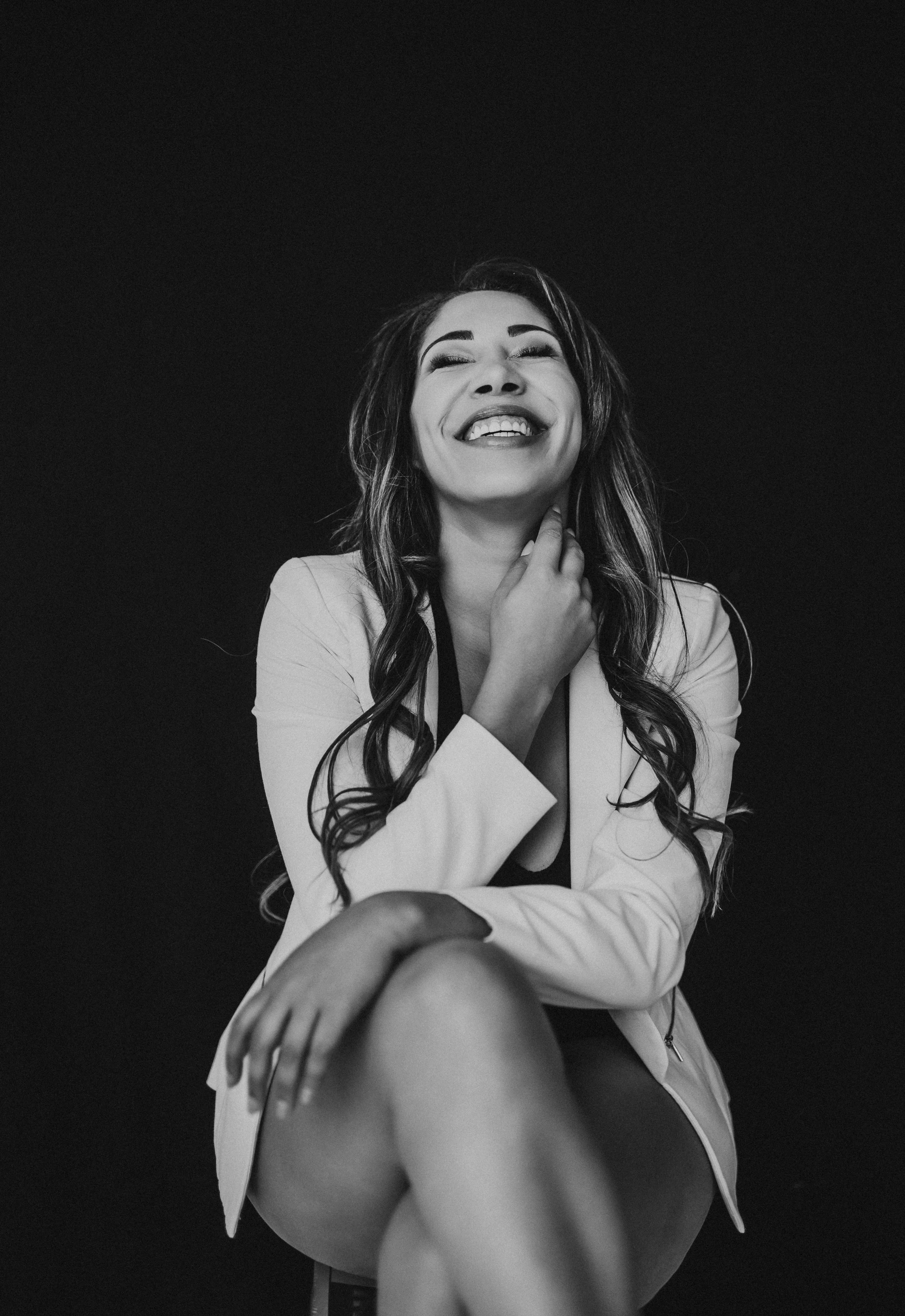 brunette in blazer smiles at sky in Hannah Mac Studios