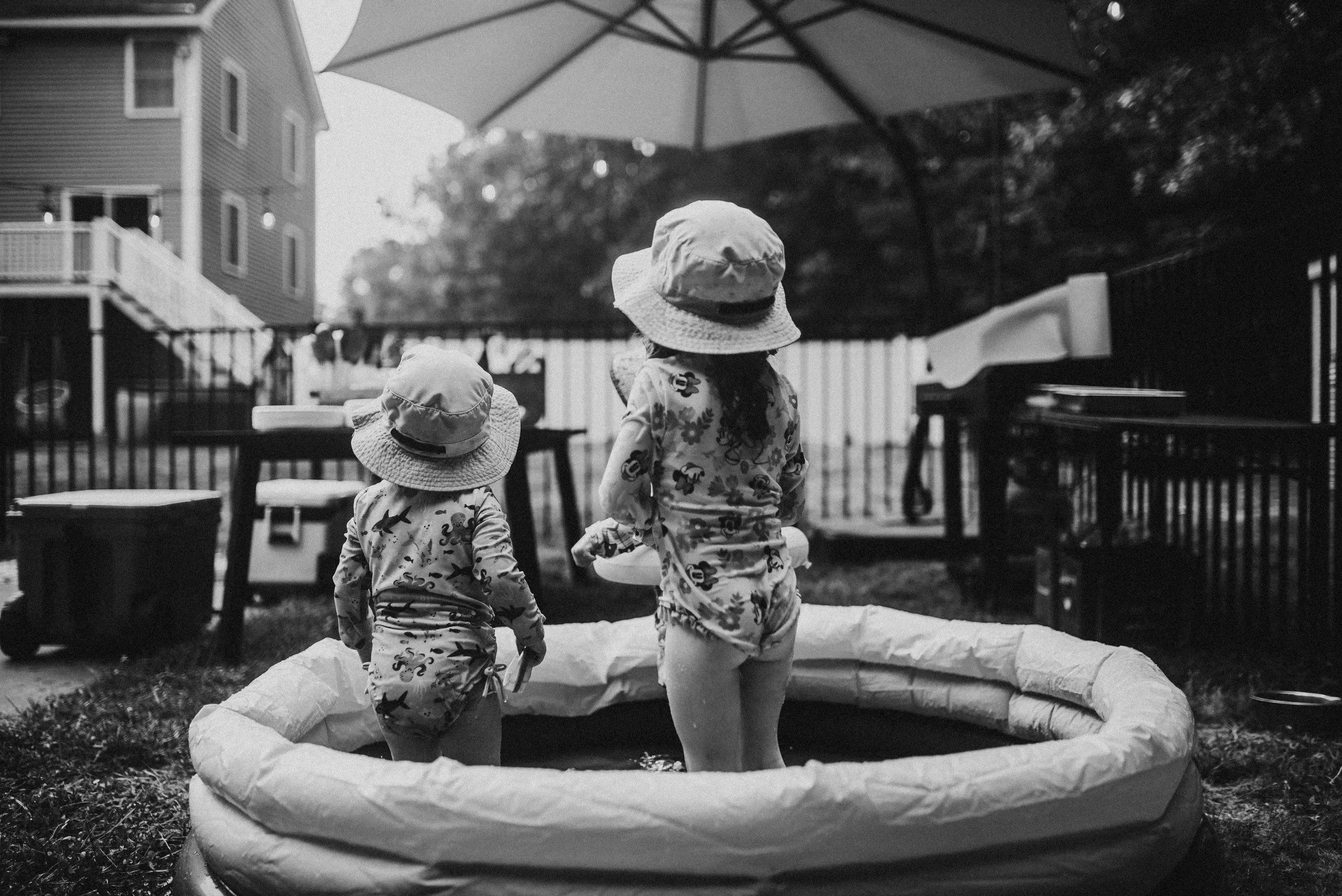 two small children in a small backyard pool by Hannah Mac Studios
