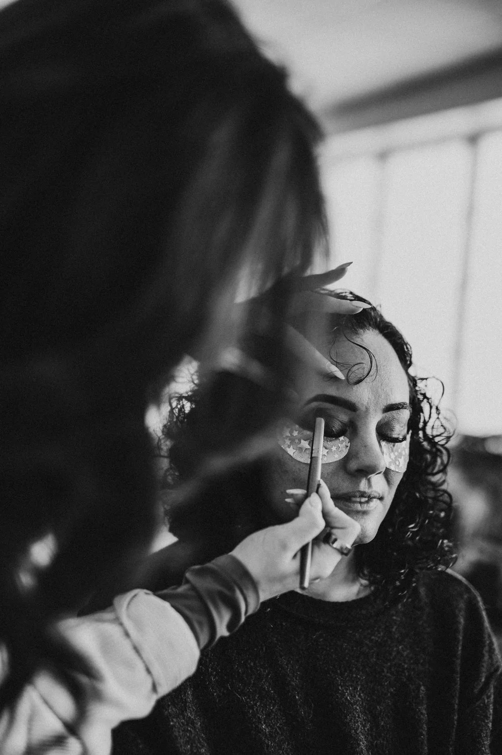 model has makeup applied before photo session in a Dover studio 