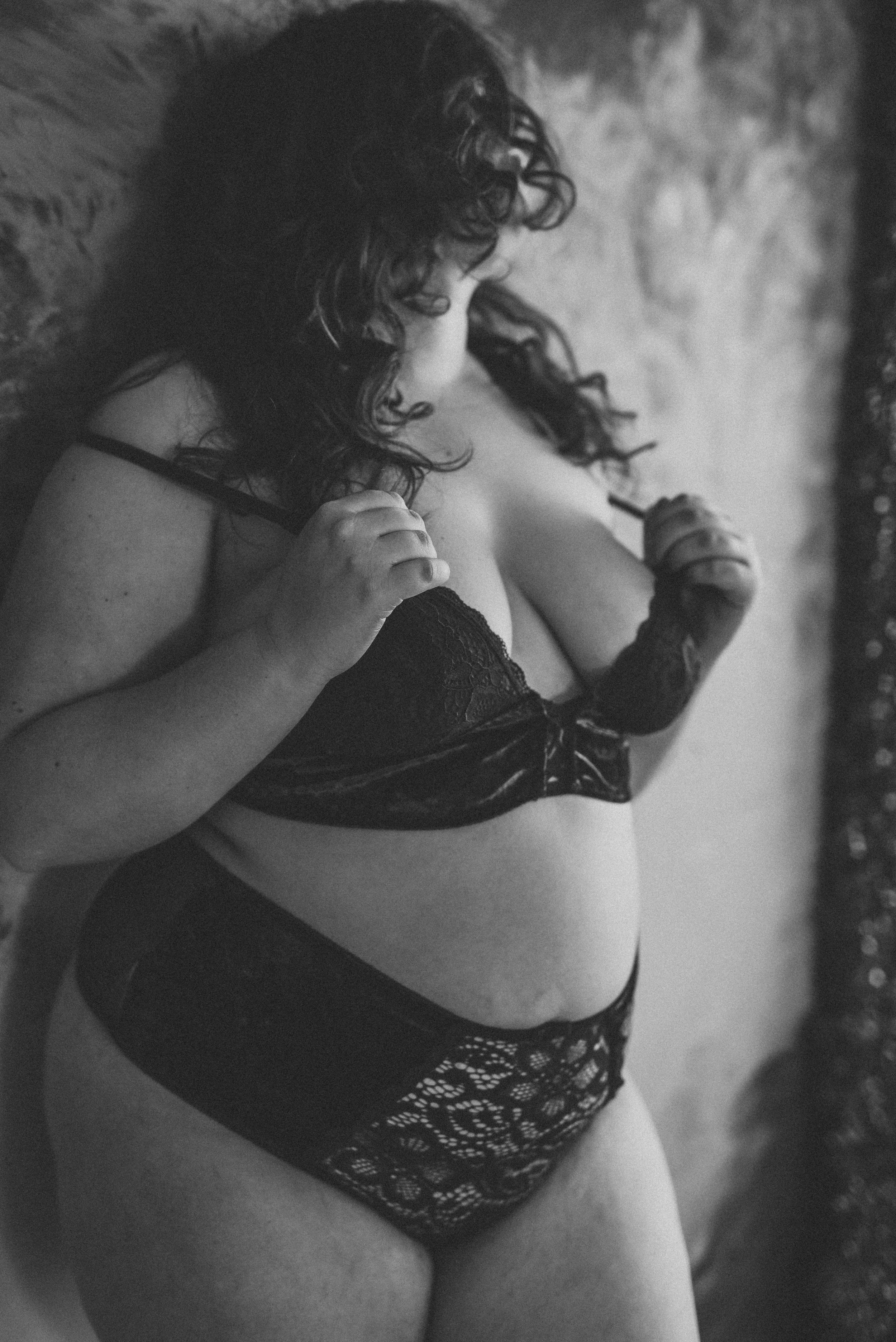 Black and white photo of a person in lingerie, featuring lace and velvet materials.
