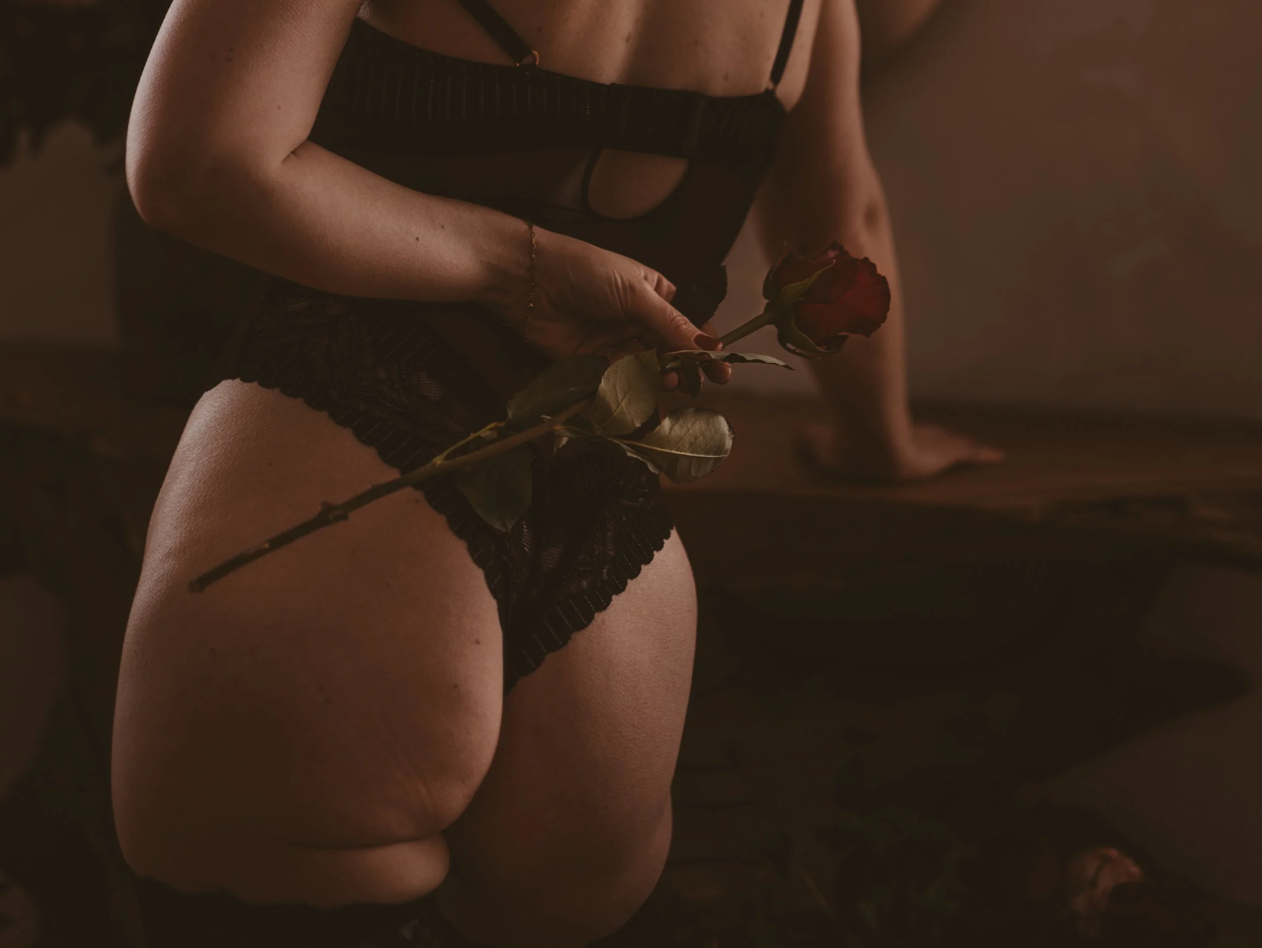 Woman holds rose behind her back at studio in Dover