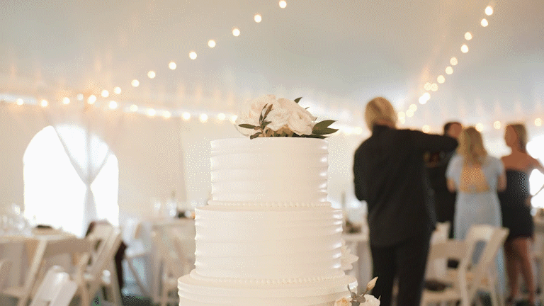 White wedding cake with floral decoration in a decorated reception hall