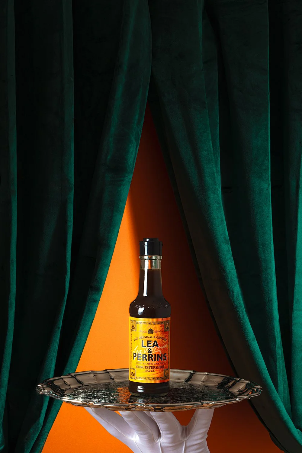 Lea & Perrins Worcestershire sauce bottle with fire and sparks on a striped bright orange background professional sauce photography