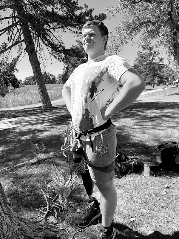 Will stands proudly, hands on hips, with climbing gear hanging on his harness. He was proud of his anchor building skills.