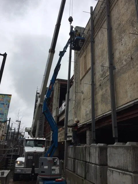 Boom lift installing steel tie-rod restraints through the heritage façade