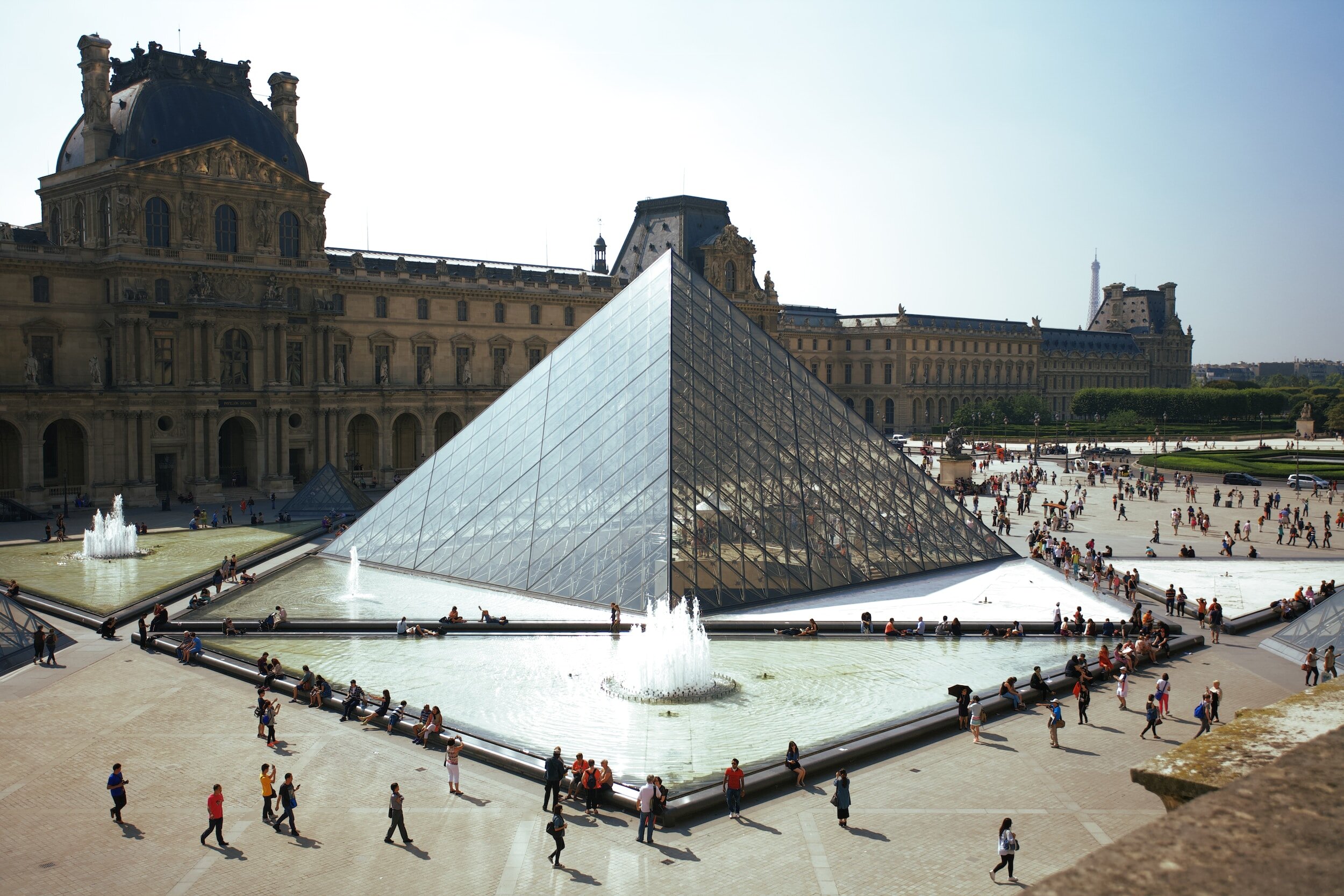Louvre Pyramid and Museum courtyard with tourists