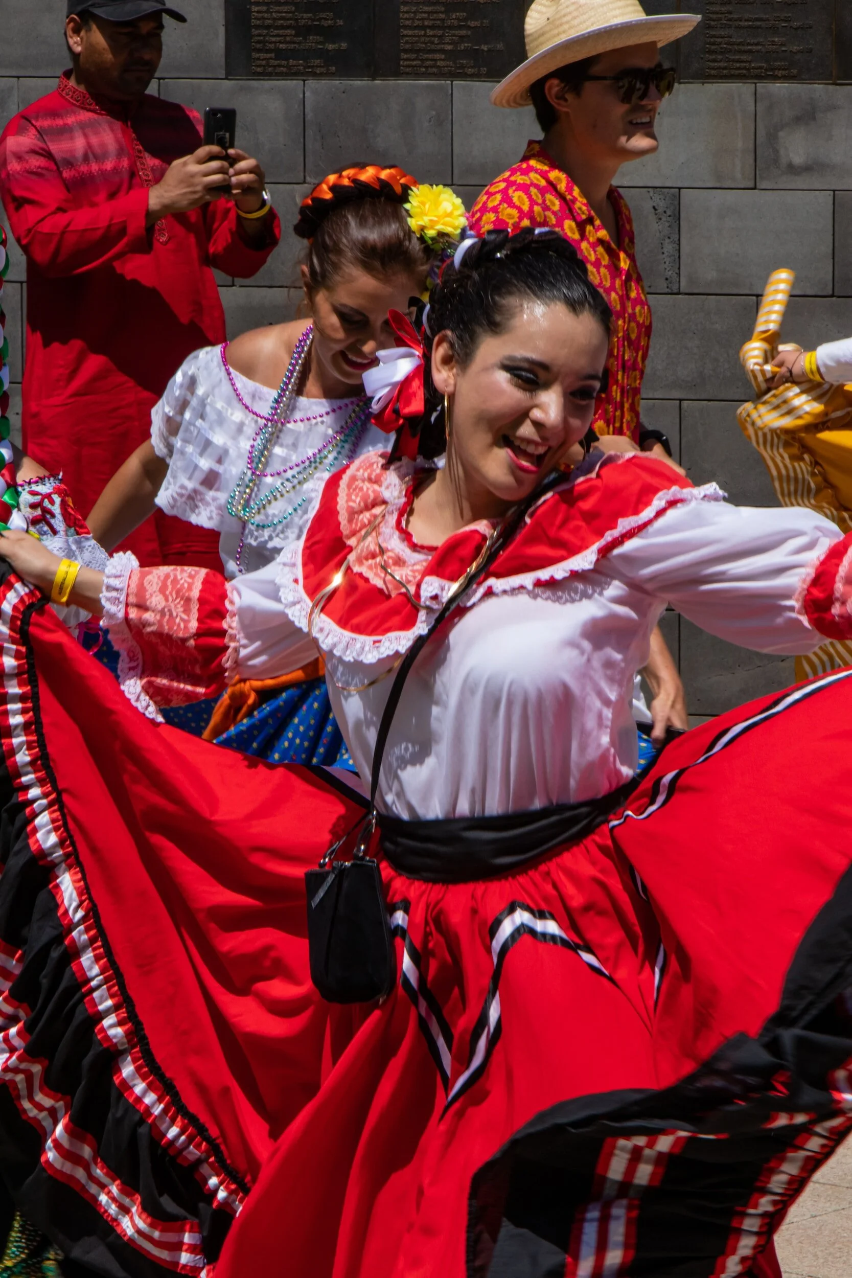 People dancing in colorful traditional clothing at a cultural festival.