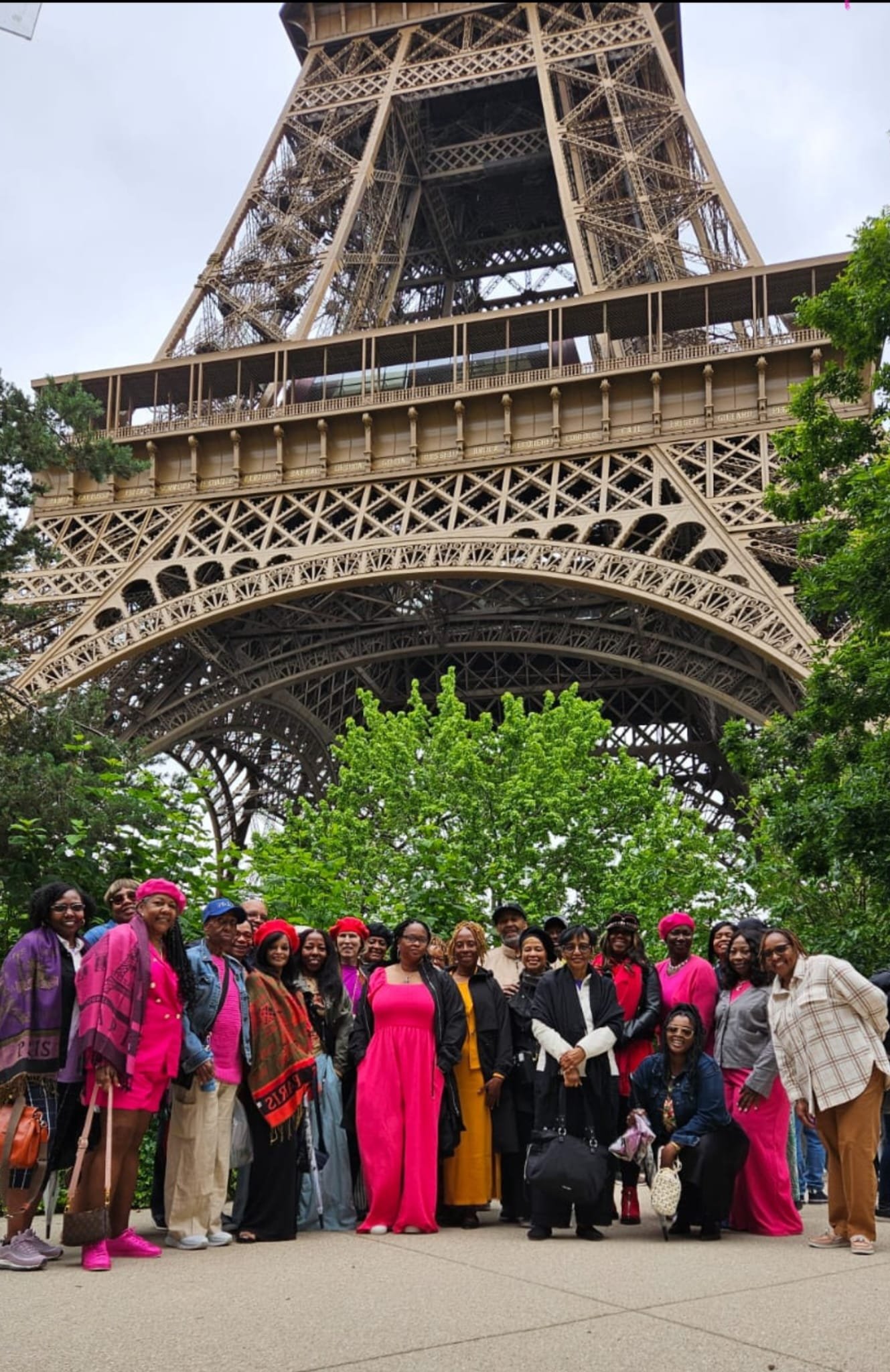 Group of people posing under the Eiffel Tower.