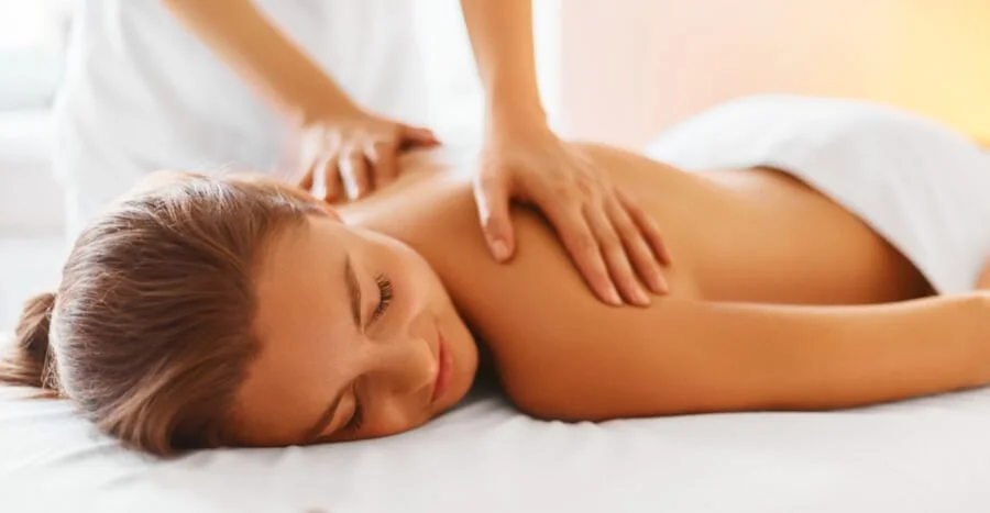 Woman receiving a back massage while lying face down on a massage table