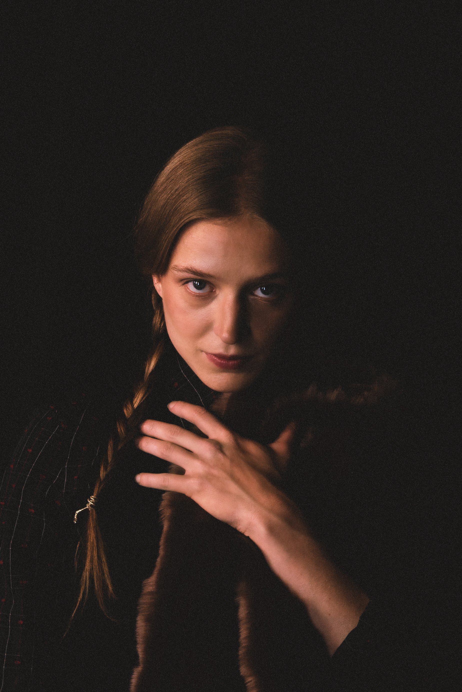 Close-up of numerous burned garlic cloves scattered on a black background.