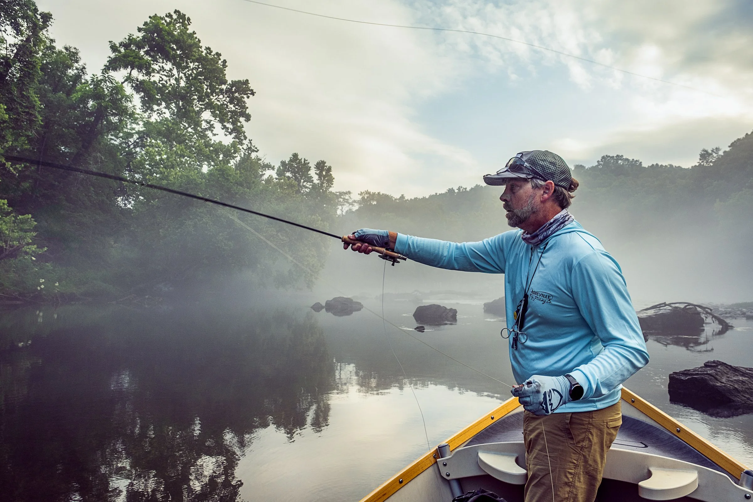 Guided fly fishing trip with Asheville Fly Fishing Company on a foggy river near Asheville, North Carolina. Photographed by Lange Photo Studio.