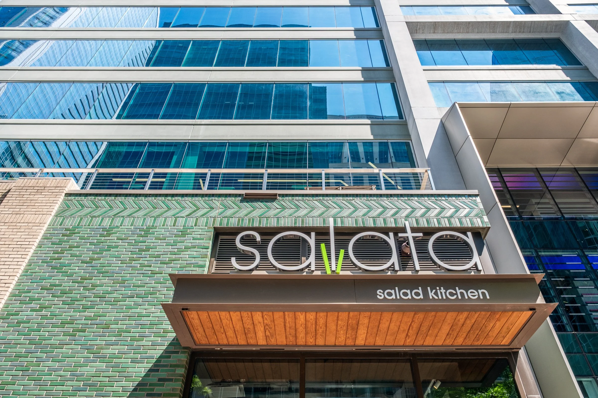 Daytime exterior view of Ally Charlotte Center, highlighting its modern architecture and urban setting in Uptown Charlotte.”