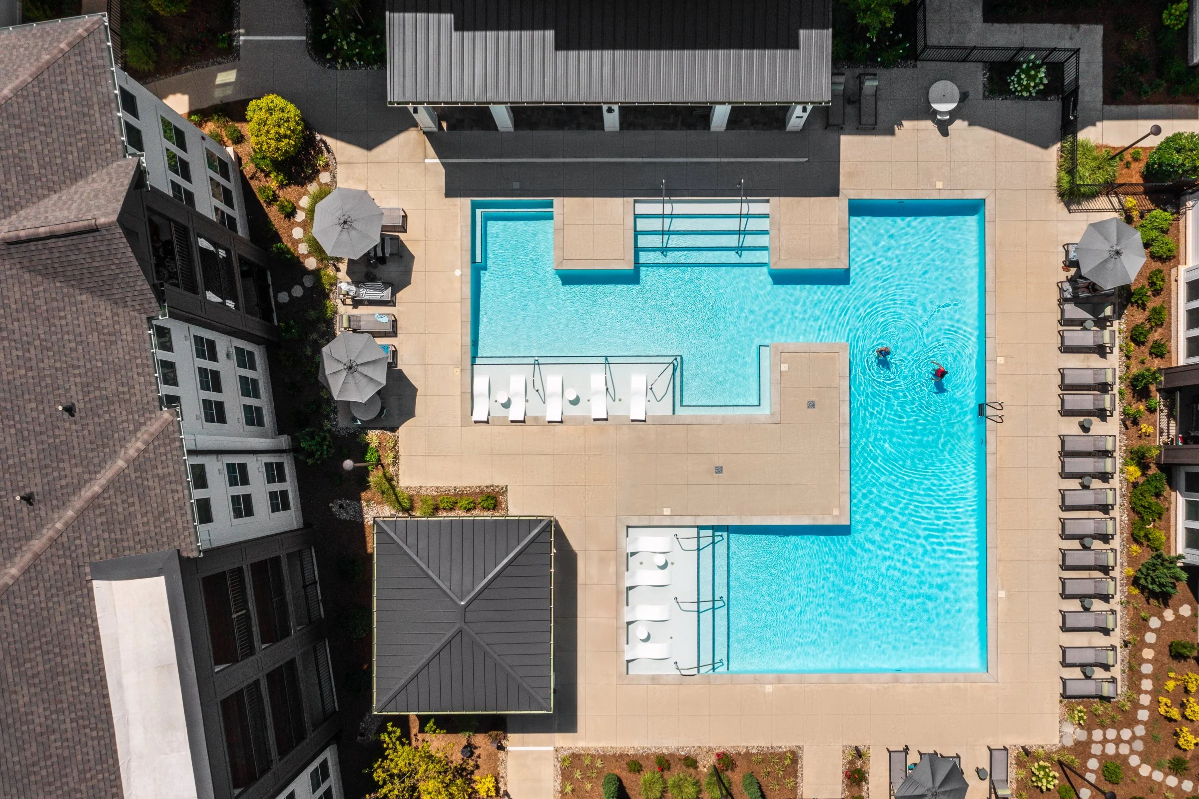 Connery on Providence 55+ community pool and adjacent amenity space, showcasing drone photography landscape design and seating areas, Charlotte, NC. Created by Lange Photo Studio. 