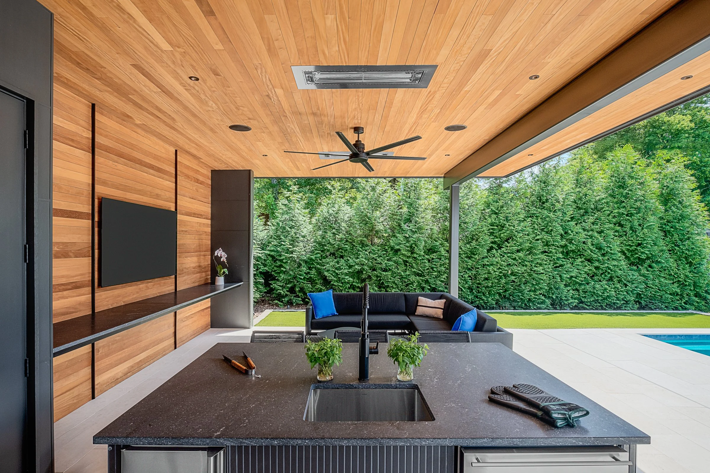Modern pool pavilion architecture featuring clean lines, natural materials, and seamless indoor-outdoor living spaces in Charlotte, North Carolina. This contemporary structure showcases floor-to-ceiling glass walls, exposed wooden beams, and a minima