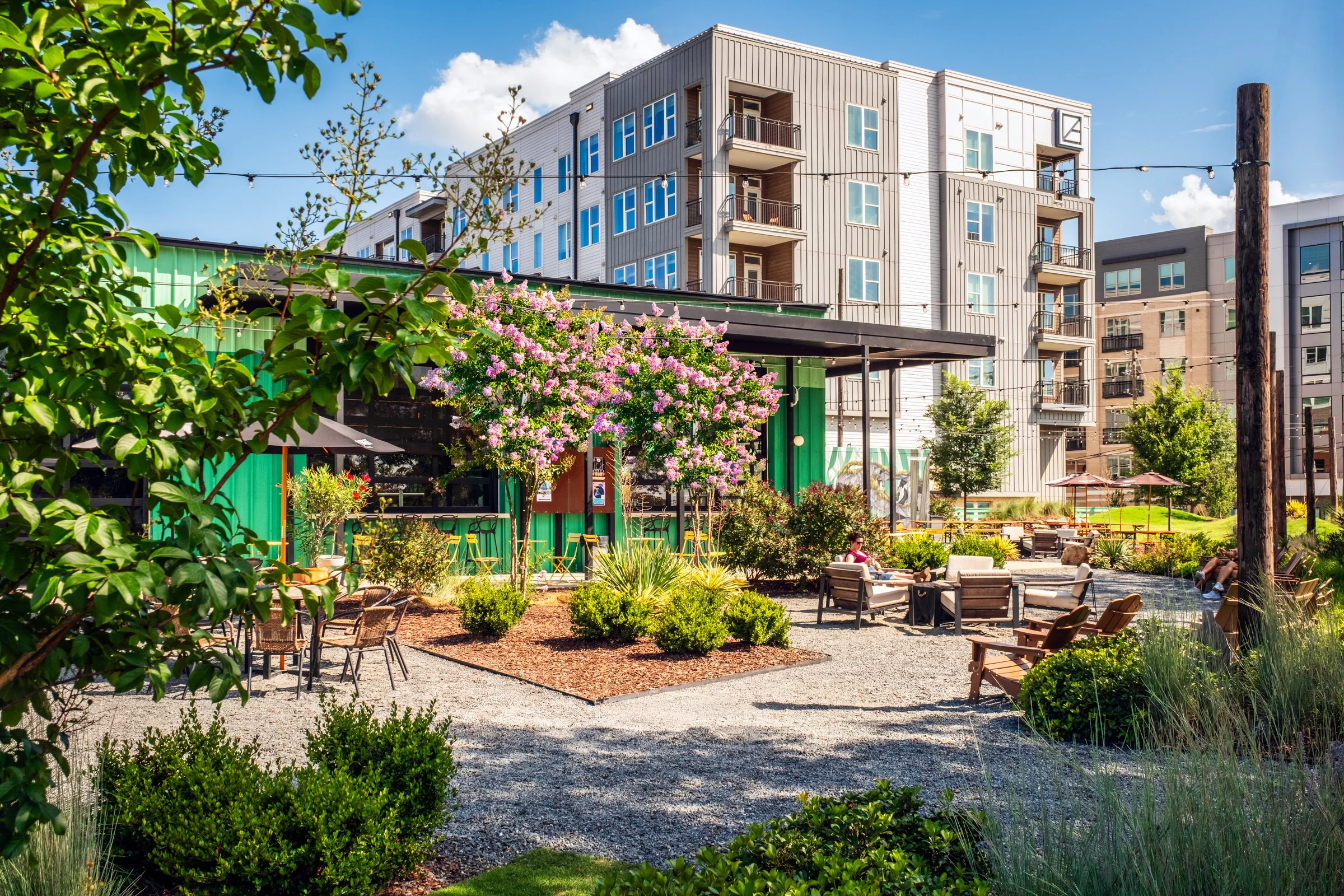 Architectural and landscape photography of Monday Night Brewing Charlotte, showcasing outdoor design, green spaces, and guest activity throughout the day.