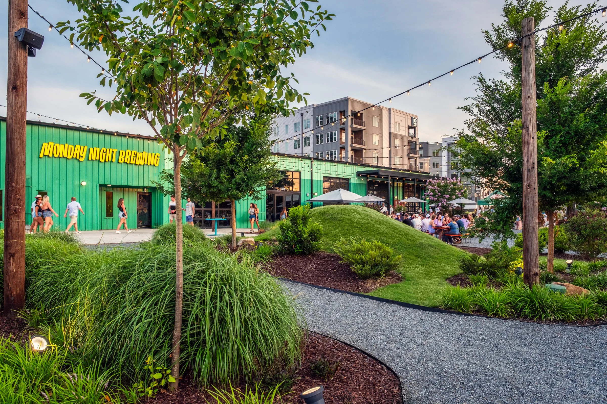 High-quality architectural photography of Monday Night Brewing, featuring landscape design details, outdoor seating, and vibrant community atmosphere.