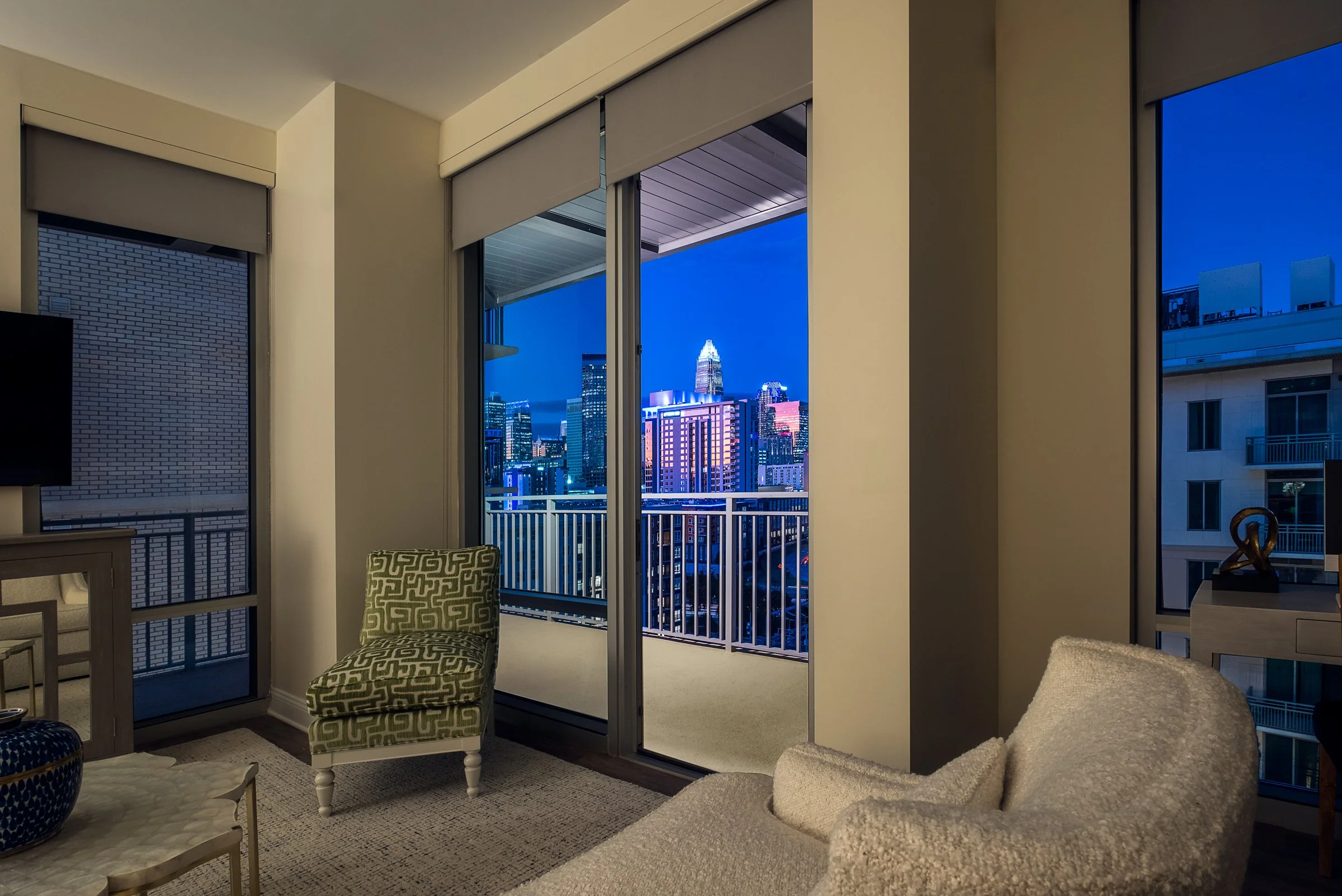 Dramatic twilight shot of Village on Morehead's illuminated glass facade reflecting evening colors