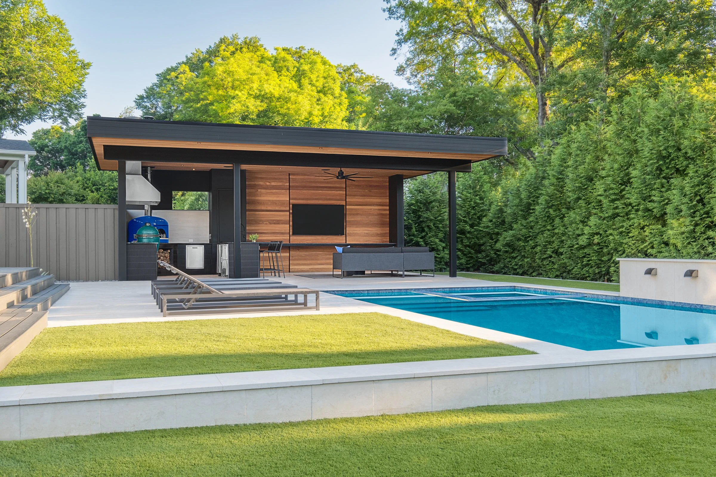 Modern pool pavilion architecture featuring clean lines, natural materials, and seamless indoor-outdoor living spaces in Charlotte, North Carolina. This contemporary structure showcases floor-to-ceiling glass walls, exposed wooden beams, and a minima
