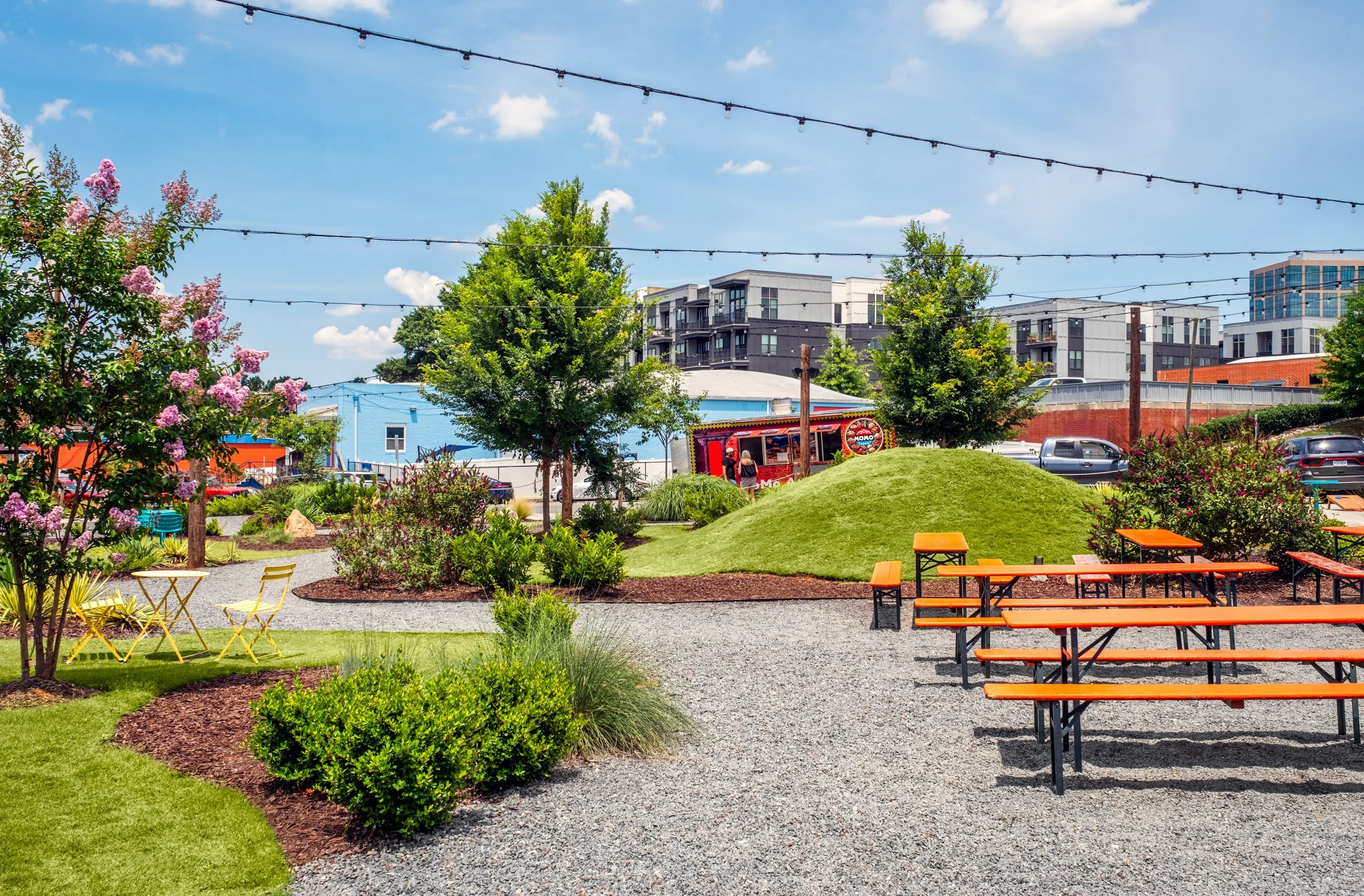 Architectural and landscape photography of Monday Night Brewing Charlotte, showcasing outdoor design, green spaces, and guest activity throughout the day.