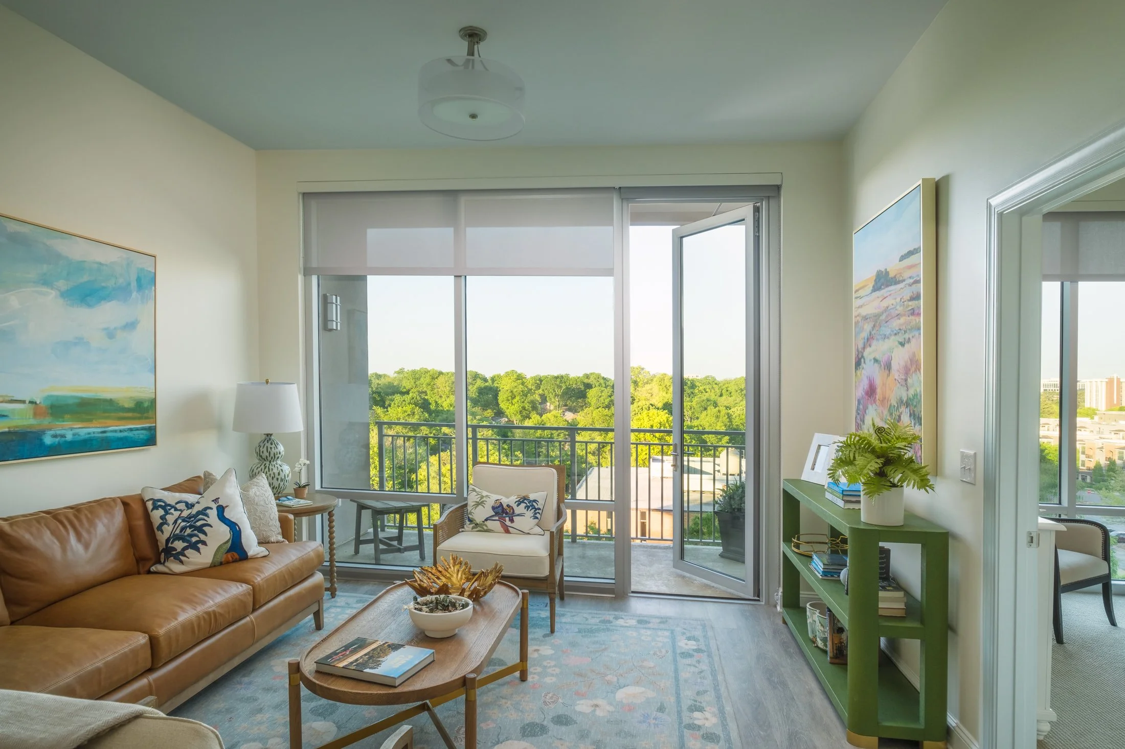 Luxury living room interior at Village on Morehead with floor-to-ceiling windows offering Charlotte skyline views