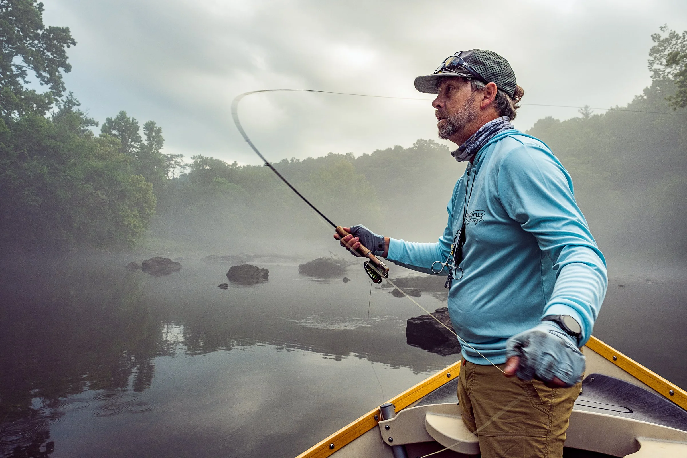 Guided fly fishing trip with Asheville Fly Fishing Company on a foggy river near Asheville, North Carolina. Photographed by Lange Photo Studio.