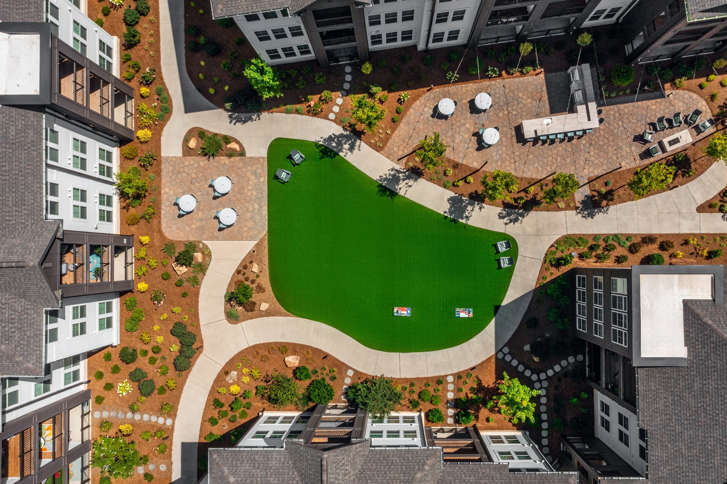 Connery on Providence 55+ community pool and adjacent amenity space, showcasing drone photography landscape design and seating areas, Charlotte, NC. Created by Lange Photo Studio. 
