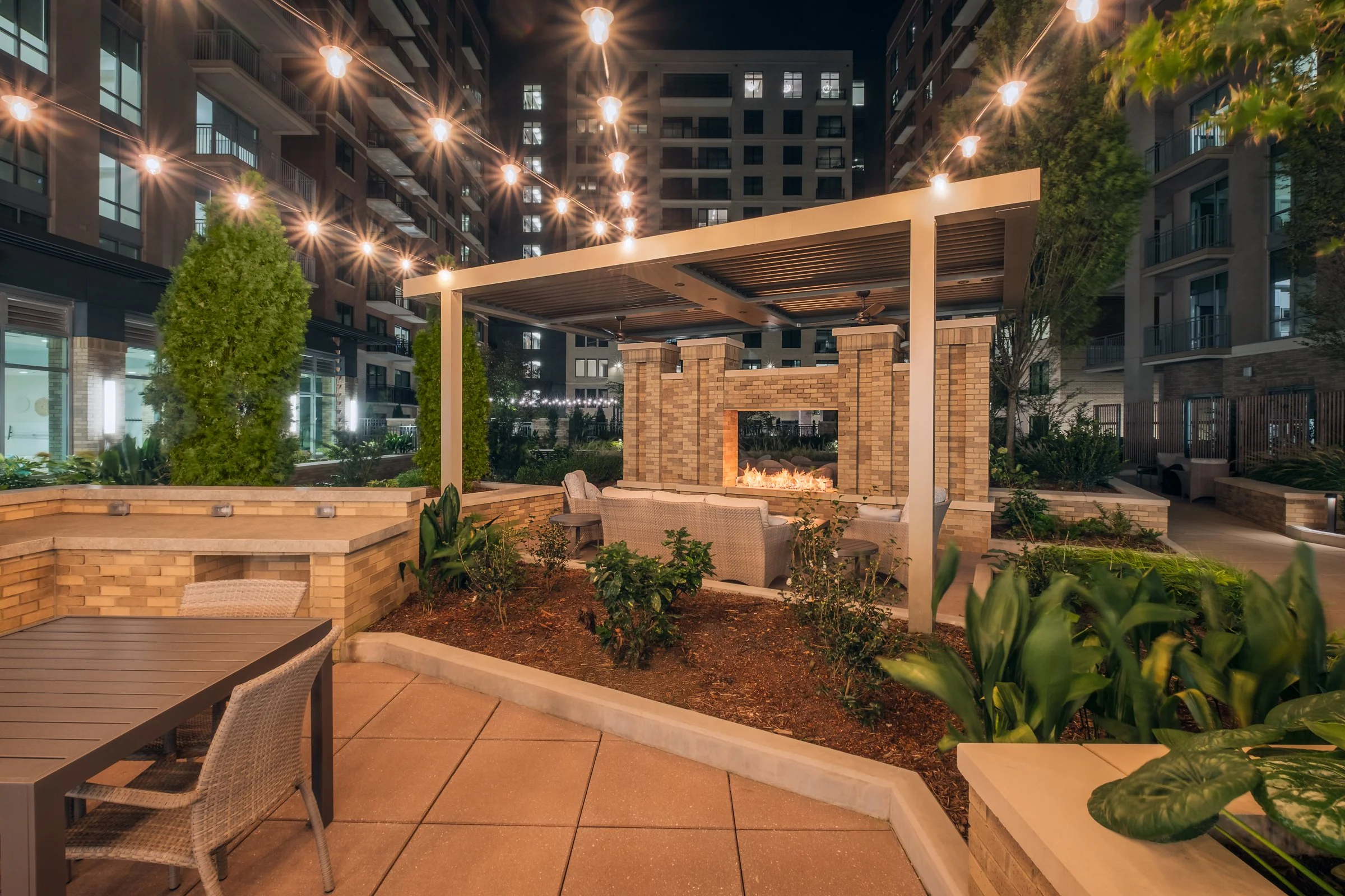 Stunning Courtyard of Village on Morehead featuring modern landscaping, seating areas, and architectural lighting