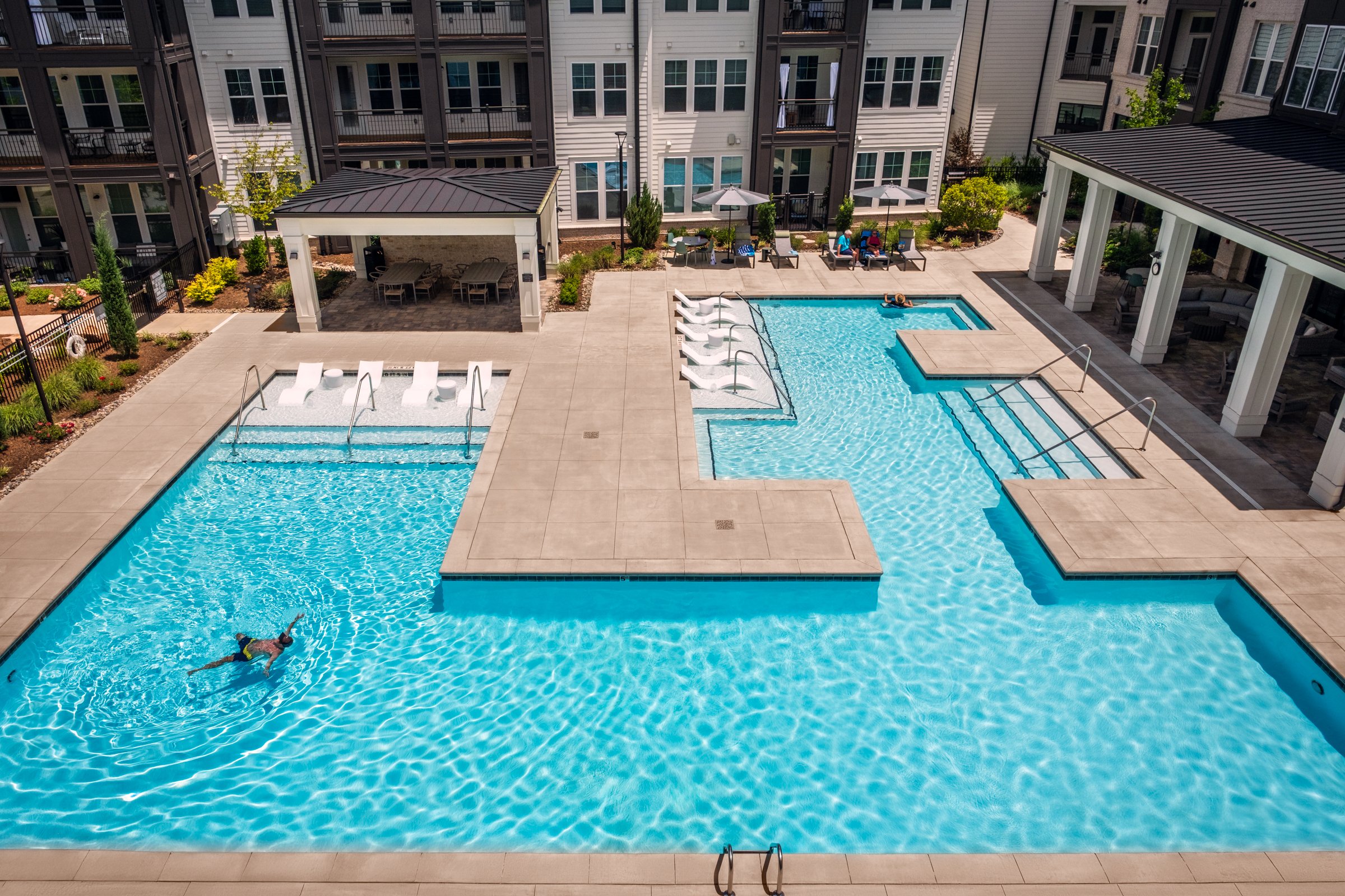 Connery on Providence 55+ community pool and adjacent amenity space, showcasing photography landscape design and seating areas, Charlotte, NC. Created by Lange Photo Studio. 