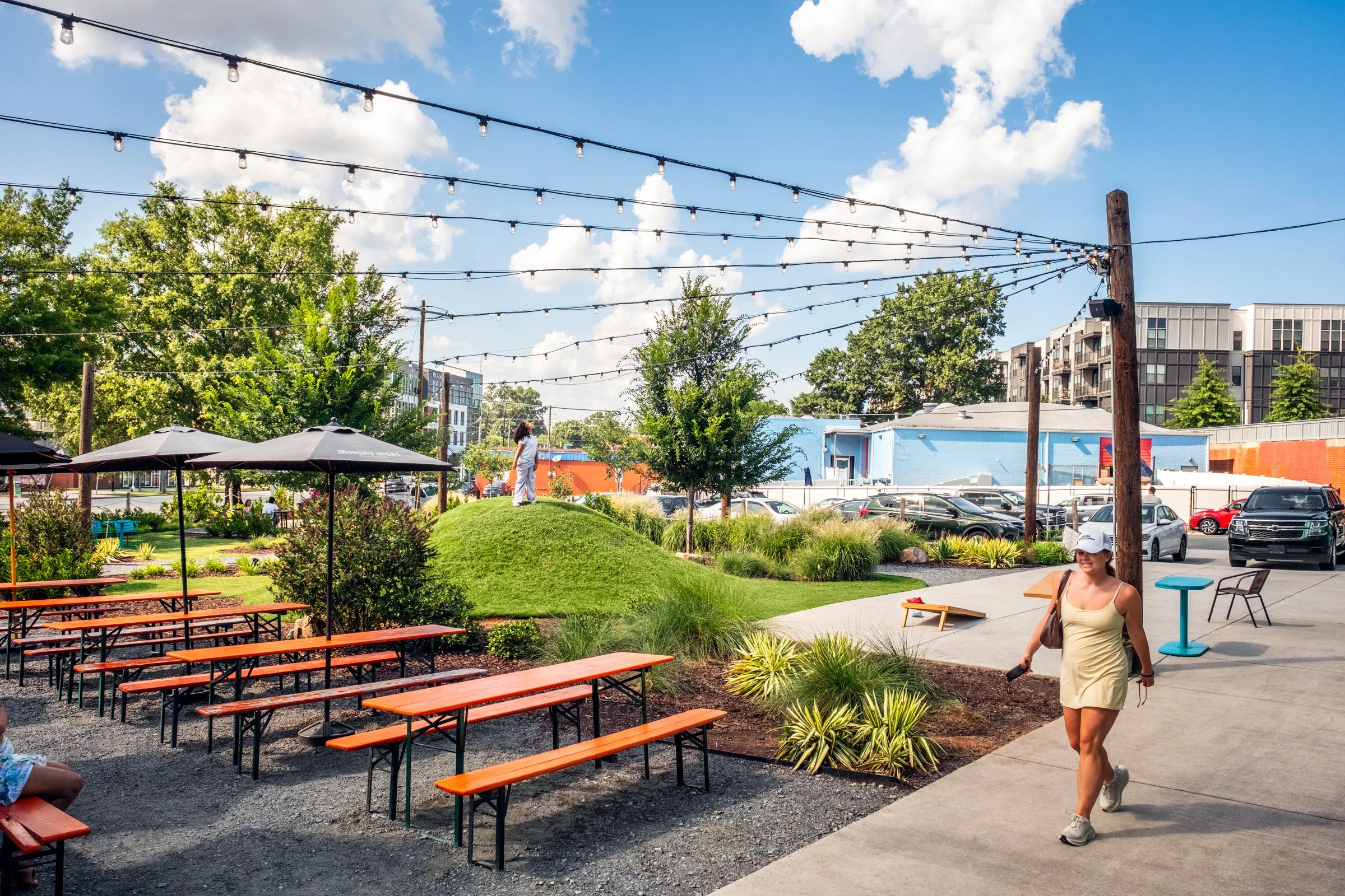 Architectural and landscape photography of Monday Night Brewing Charlotte, showcasing outdoor design, green spaces, and guest activity throughout the day.