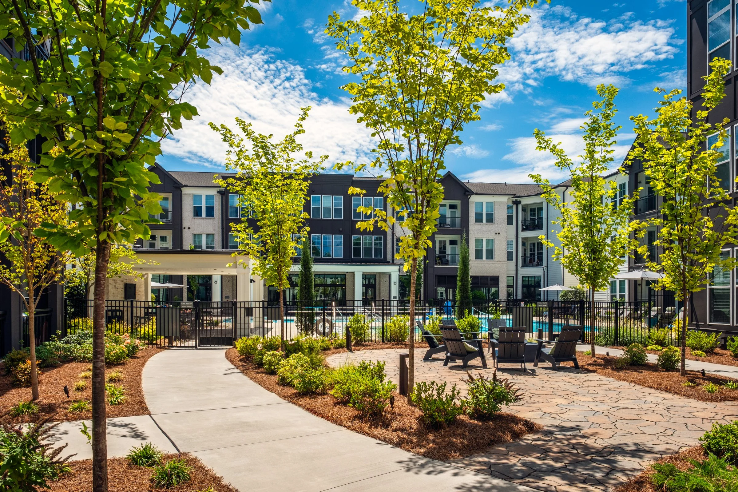 Connery on Providence 55+ community pool and adjacent amenity space, showcasing photography landscape design and seating areas, Charlotte, NC. Created by Lange Photo Studio. 