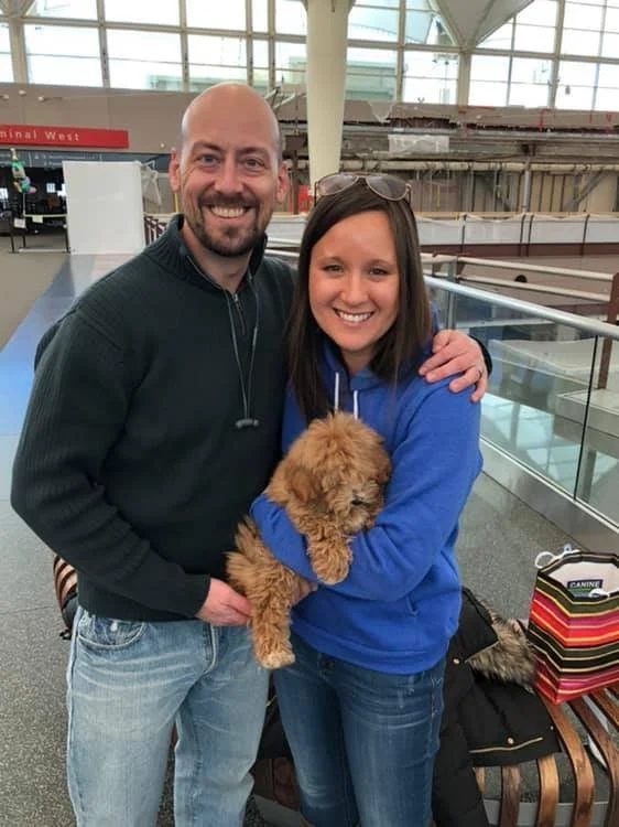 couple holding puppy delivered by flight nanny