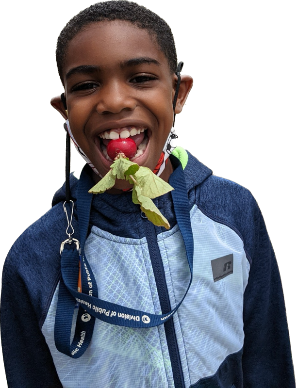 Black boy smiling with radish between his teeth