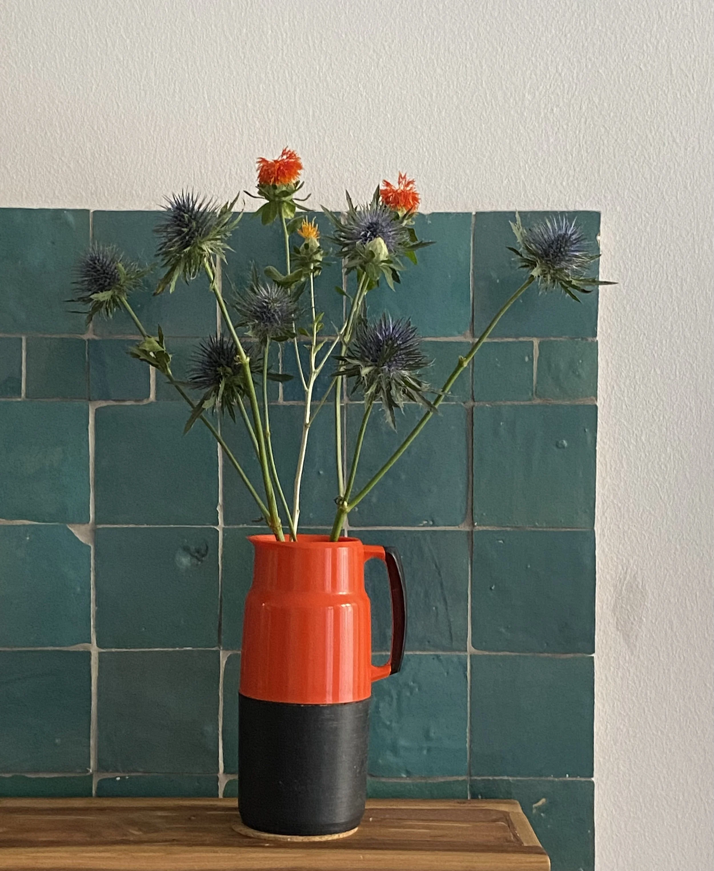 Swedish thermos with flowers against tiles.jpg