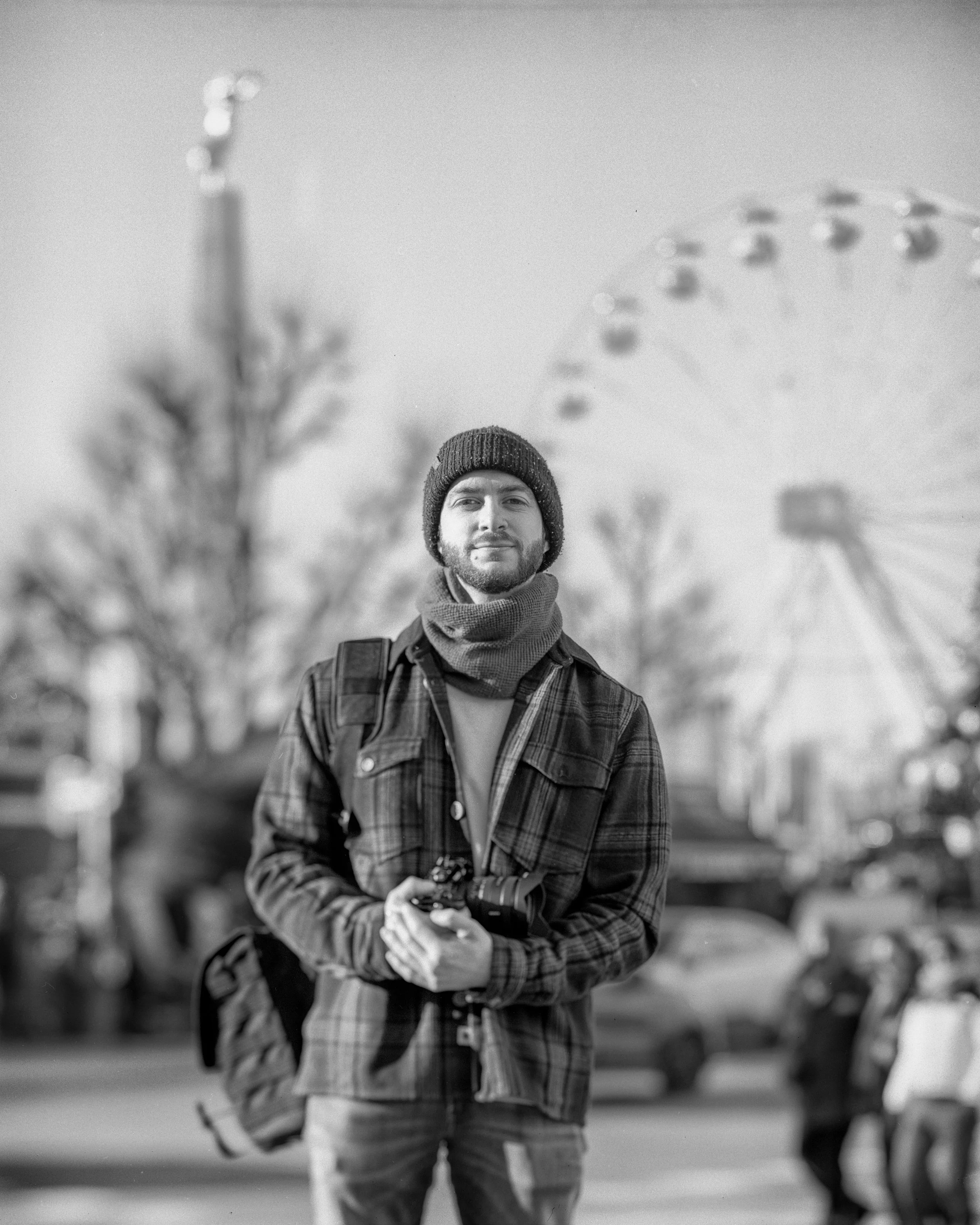 Portrait de Bastien Colas. Photo réalisé sur la palce de Luxembourg, ville avec le amrché de noël en arrière plan.