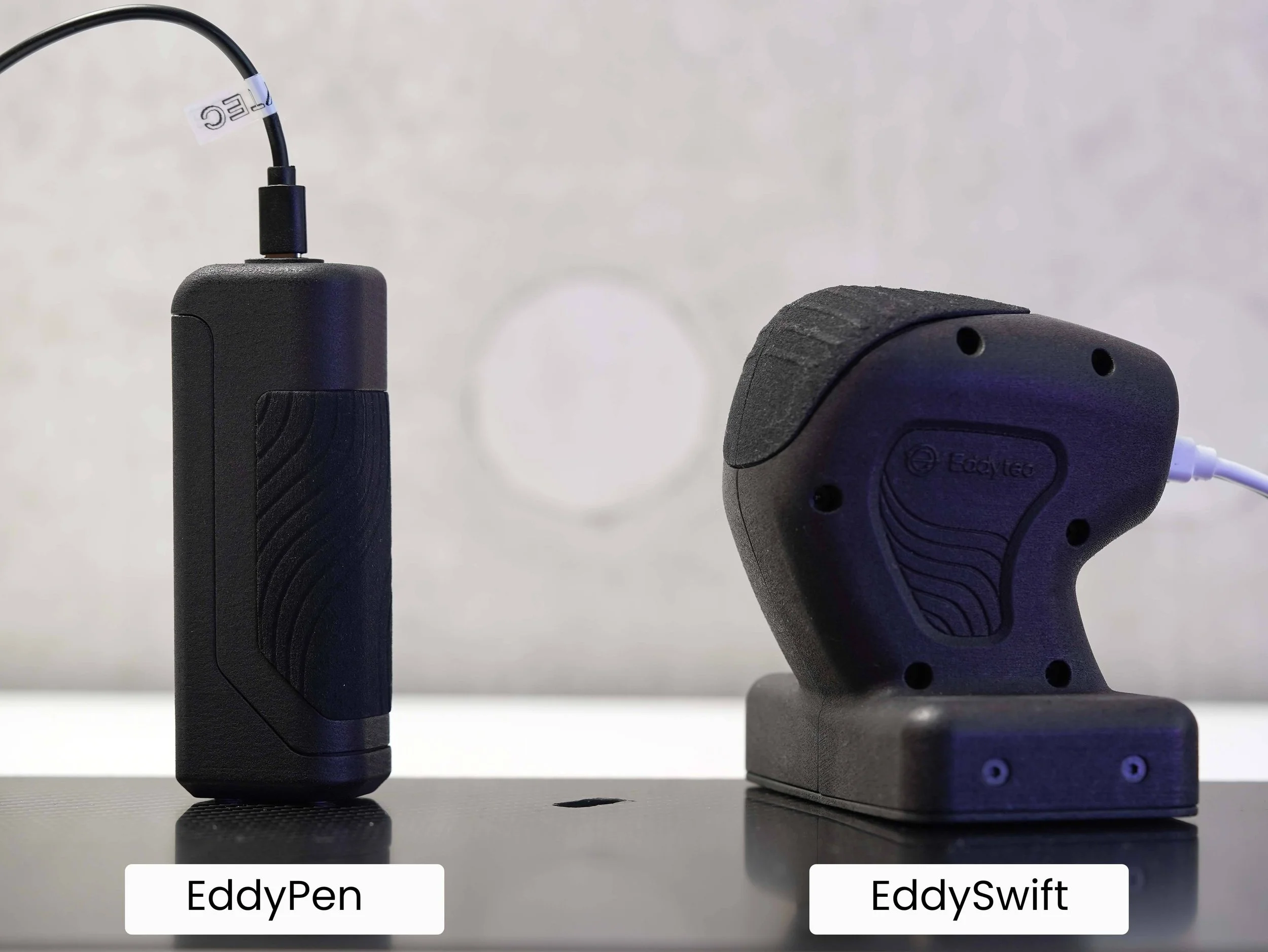 Eddytec EddyPen and EddySwift portable composite testing devices shown on a piece of carbon with defect