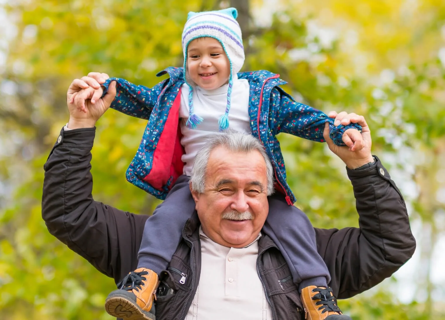 Abuelo with happy child sitting on his shoulders