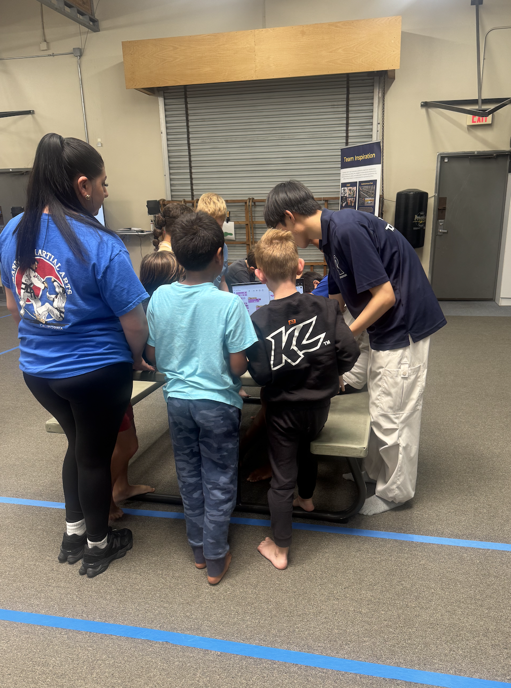 Team Inspiration member teaching students how to code lego robot