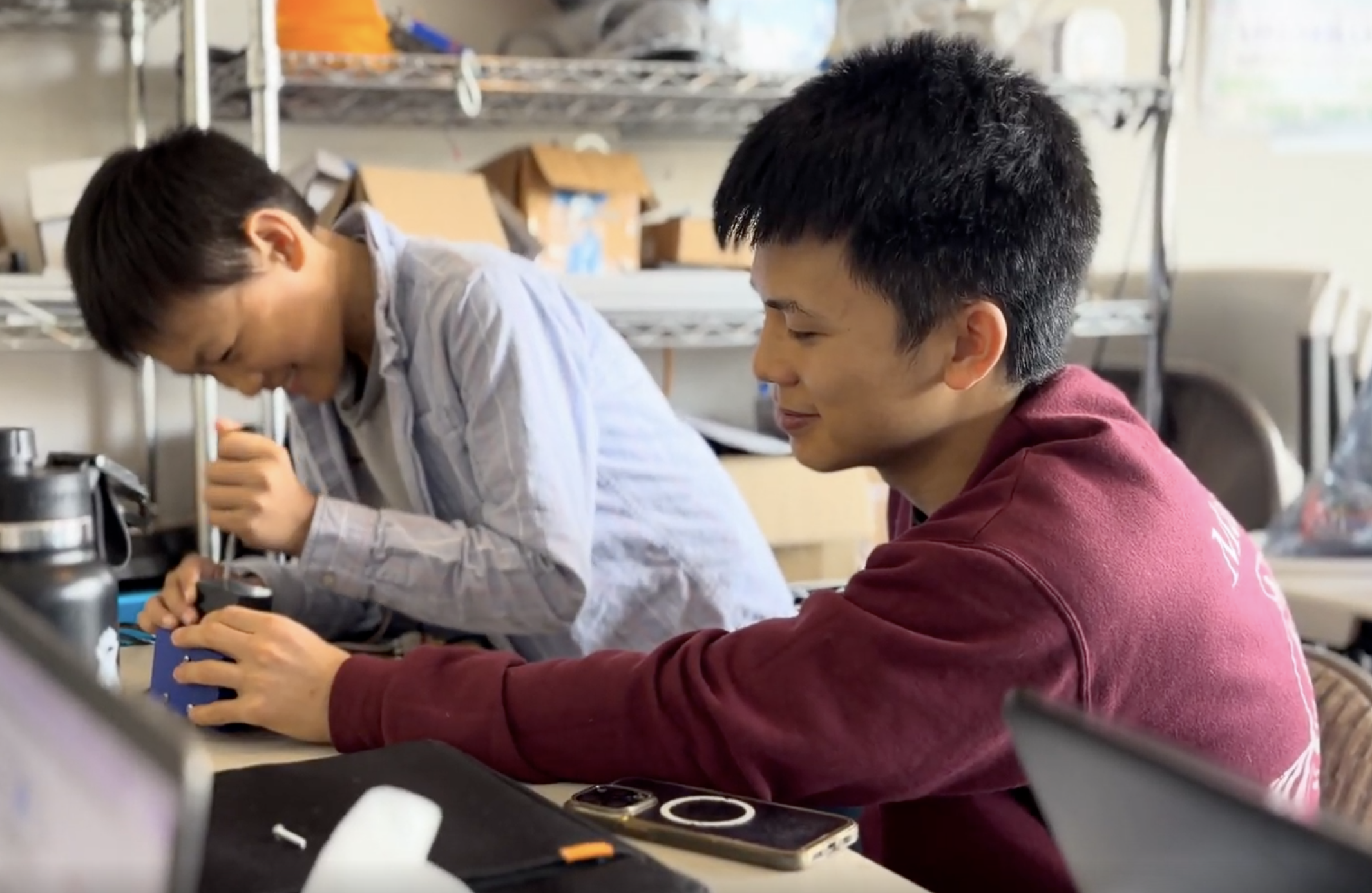 Team members collaborating on mechanical assembly.