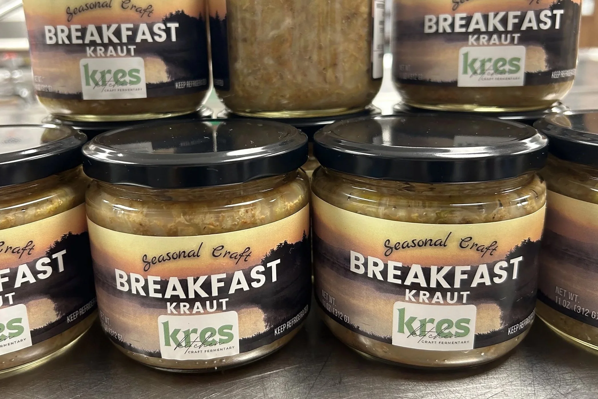 Finished jars of Kres Kitchen Breakfast Kraut lined up and stacked.