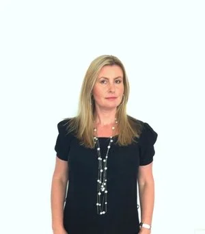Woman in black dress with long necklace against white background