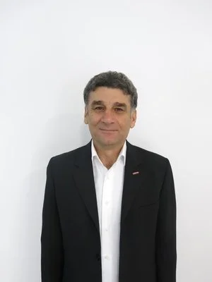 Man in a suit standing against a white background.