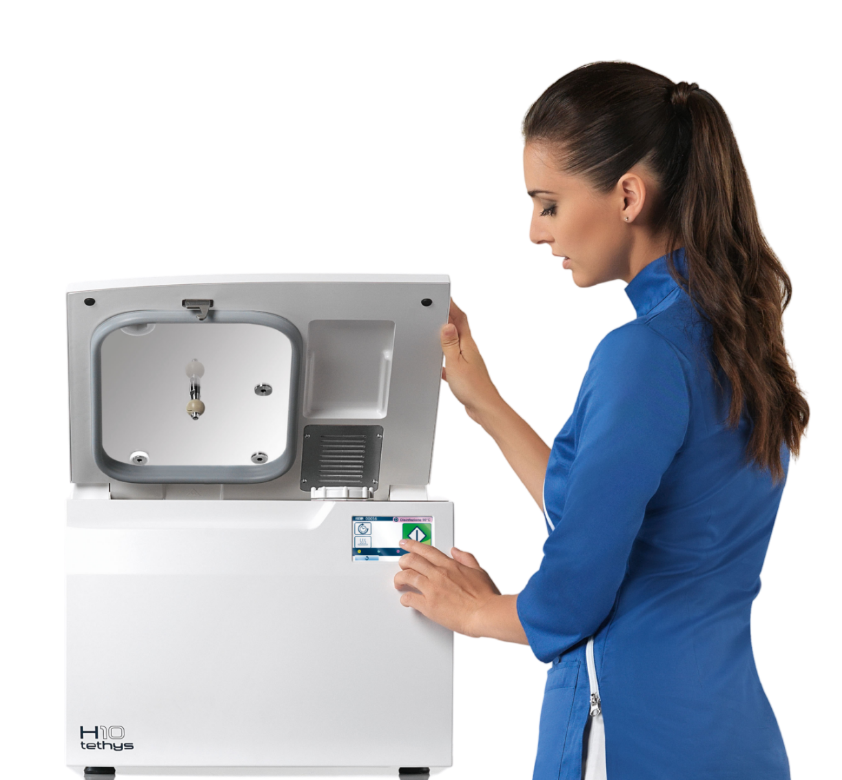 A woman in blue medical scrubs operating a medical device with an open lid and control panel.