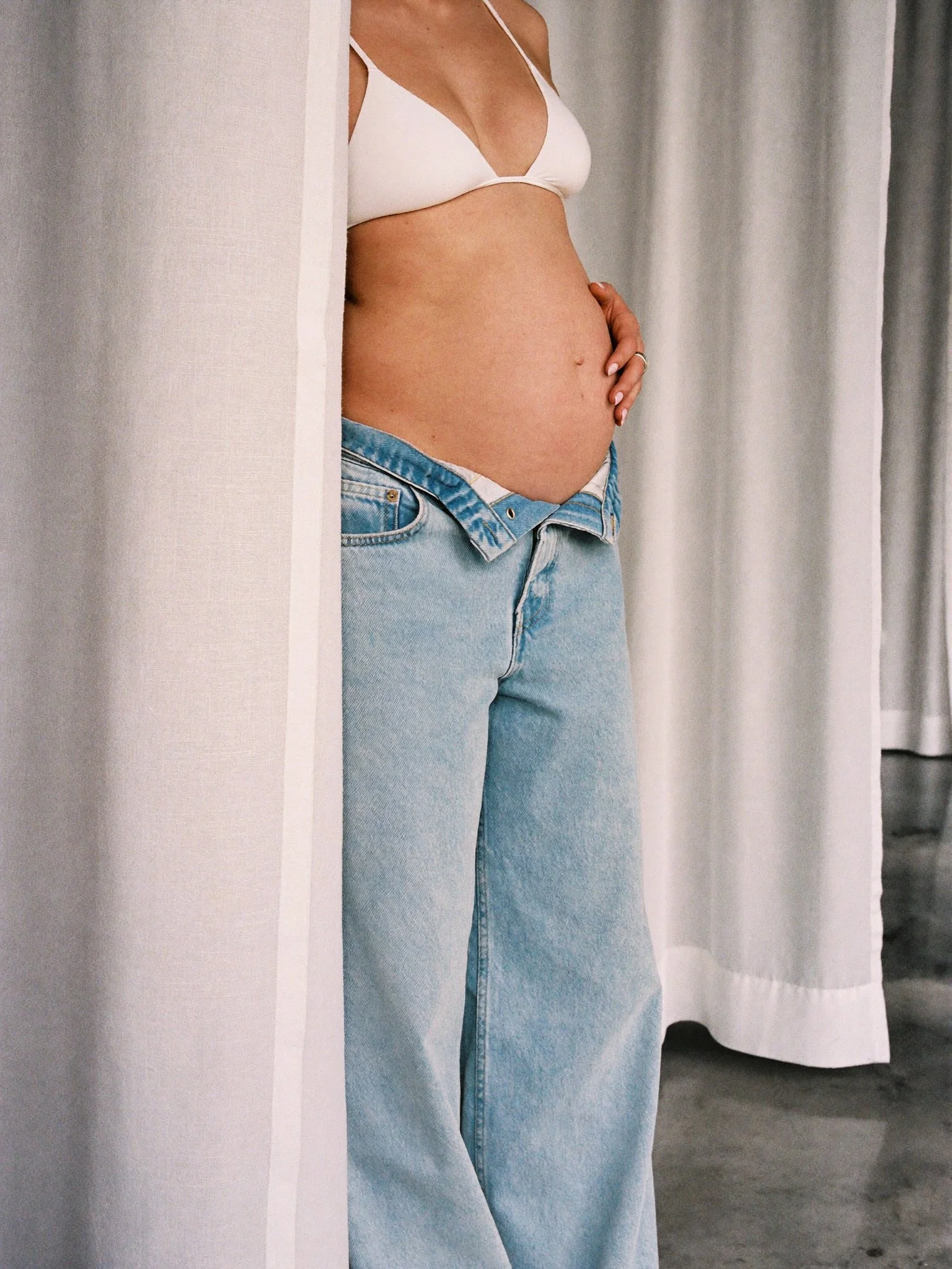 Mothers Day - Pregnant woman in white bikini top and denim jeans - TVS.jpg
