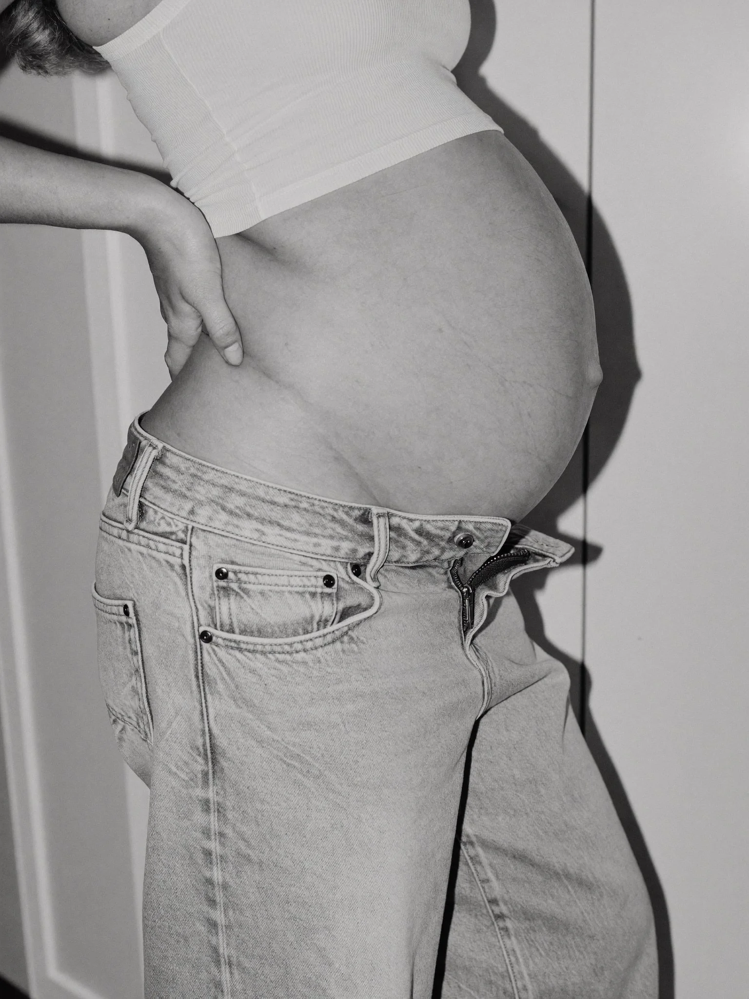 Mothers Day - Pregnant woman in white tank top touching belly - TVS.jpg