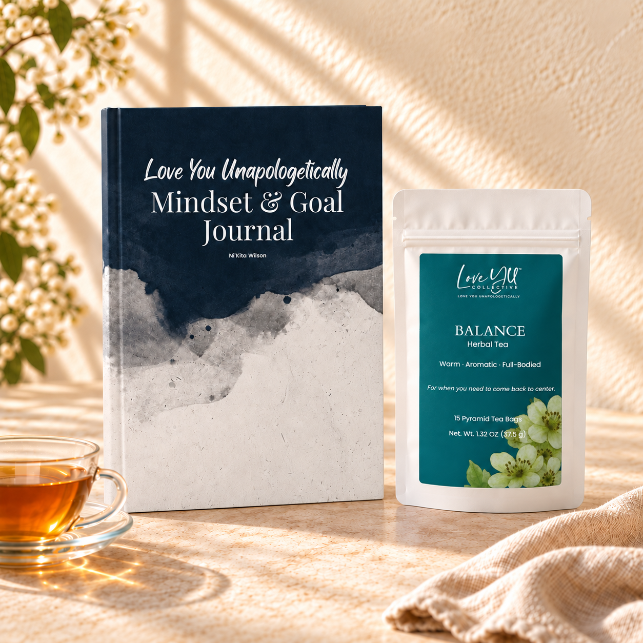 Balance tea pouch beside a navy journal-2.png