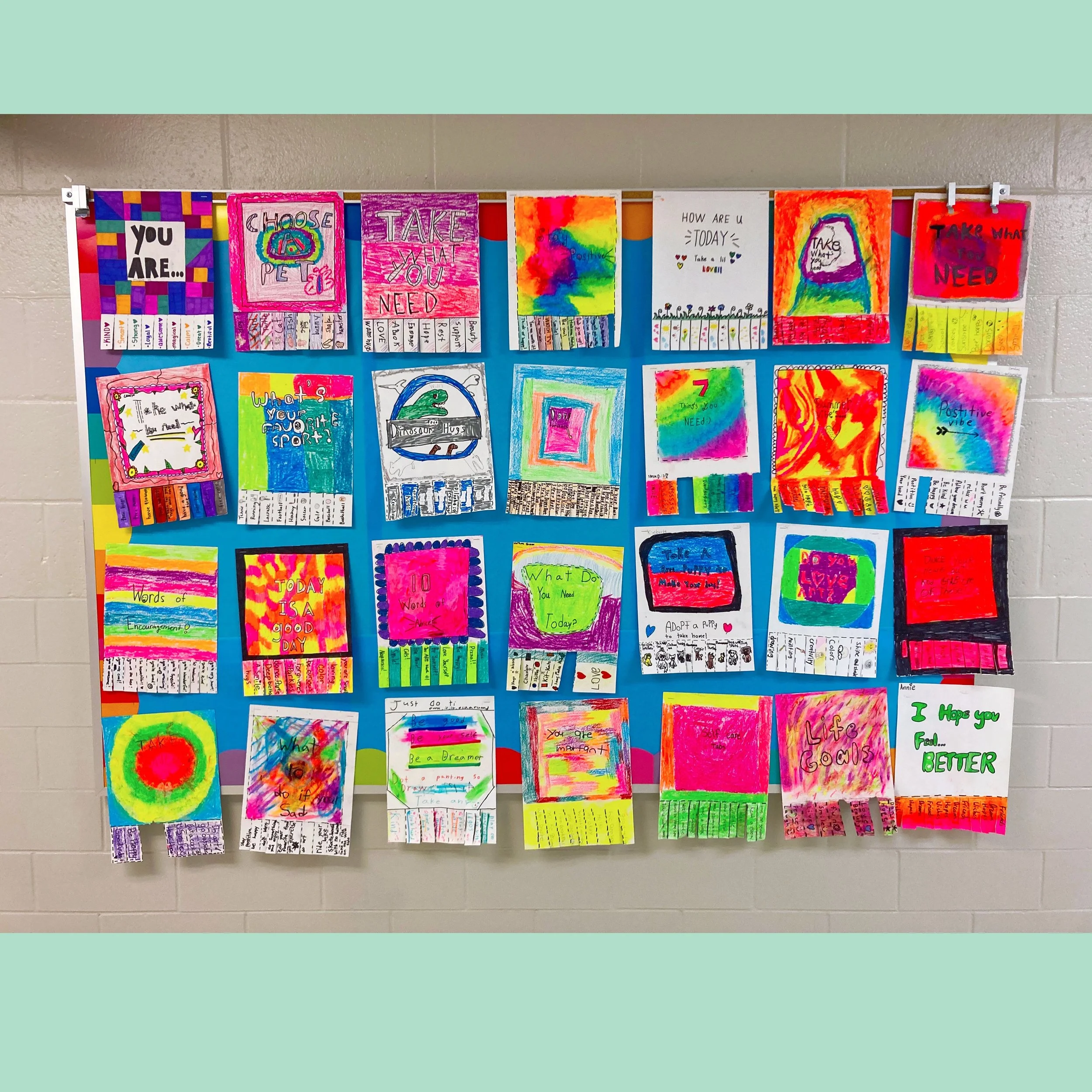 Colorful handmade posters with motivational and positive messages displayed on a blue wall.