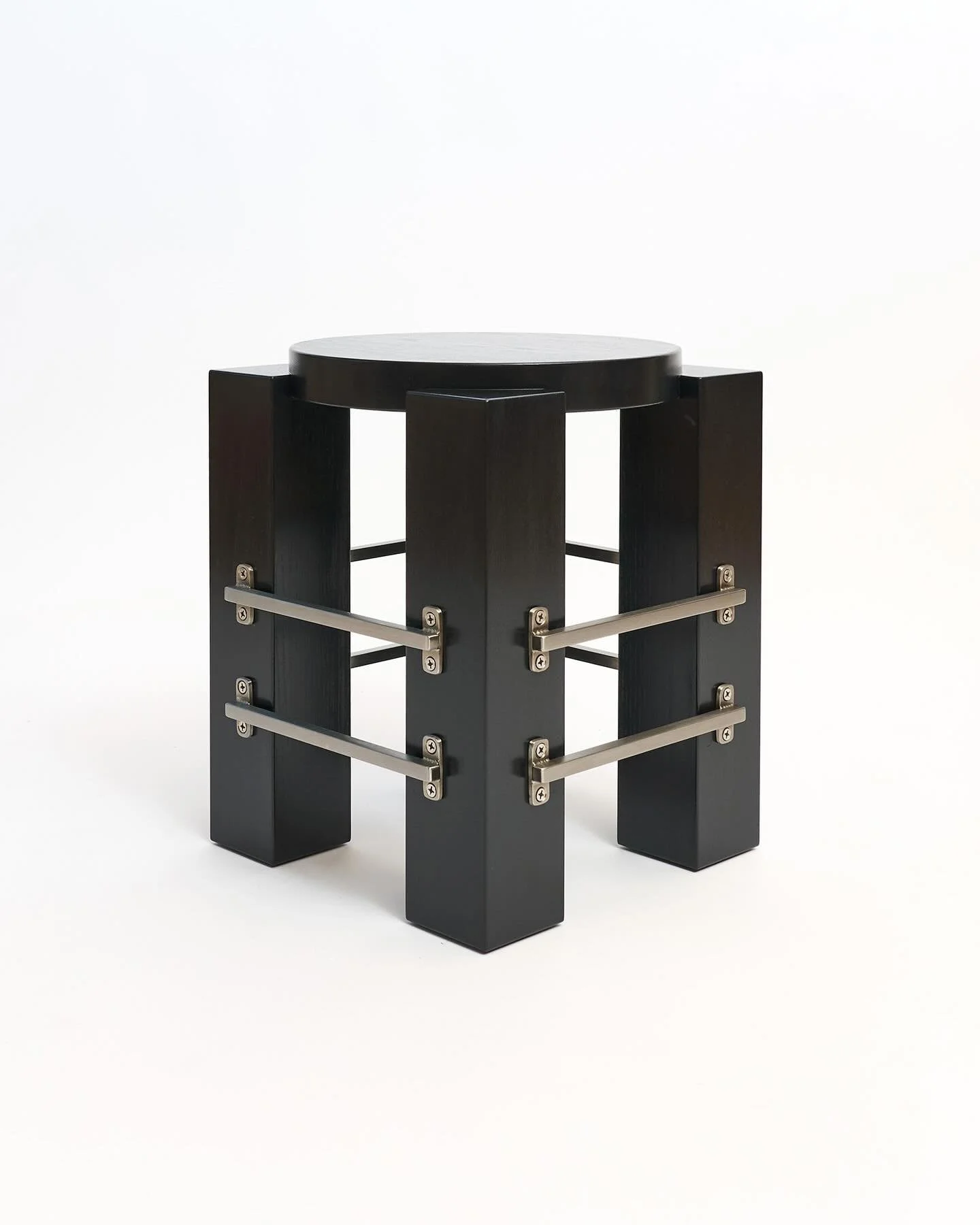 The oversized legs and circular top of the Barred Side Table create a bold geometric look. Linear bars bolted to its exterior act as the jewelry of the piece, glinting in the sun and drawing attention. Sturdy by design, this little table is strong en