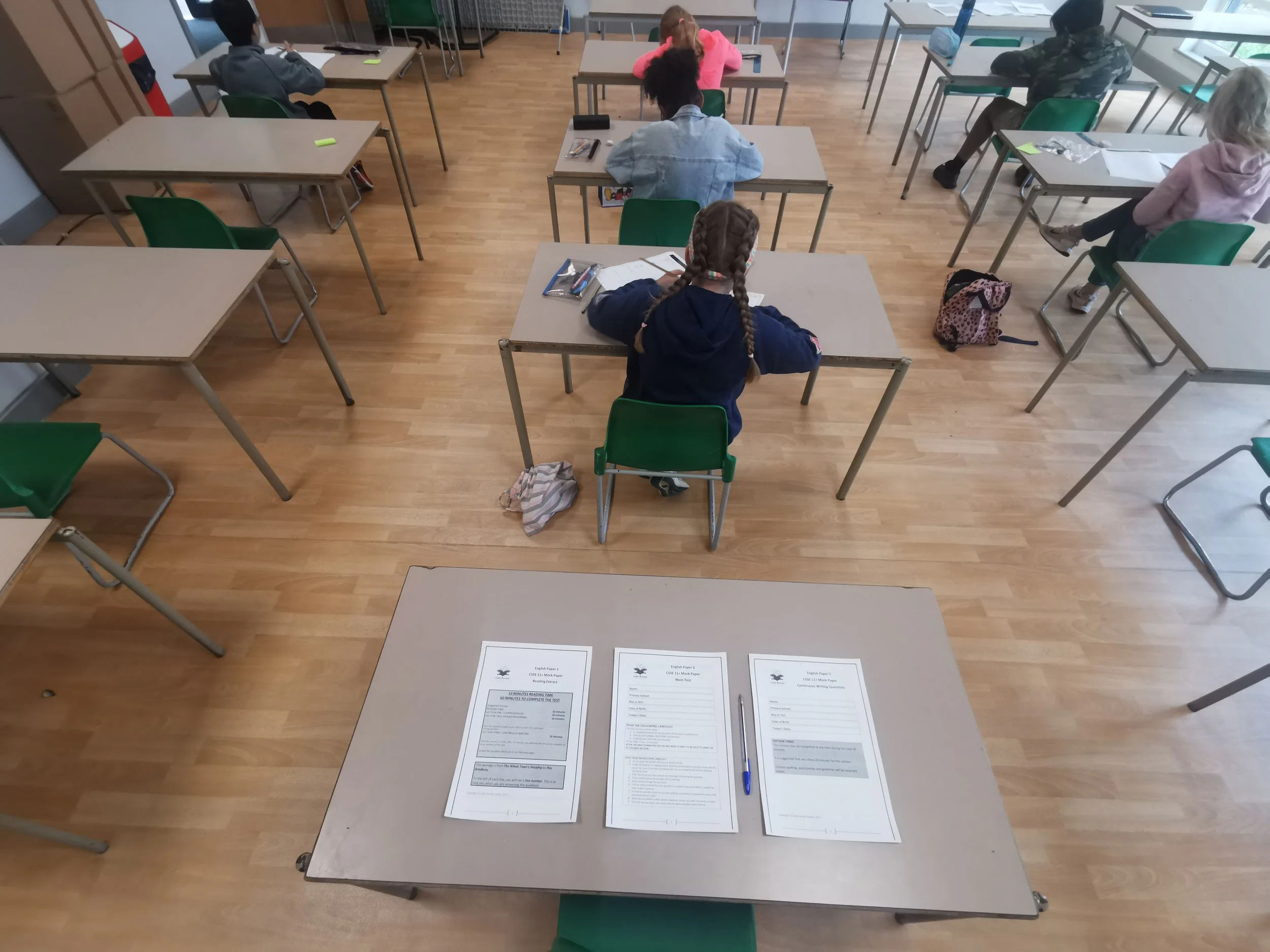 Child completing a Colin Arnold Tuition CSSE 11+ mock examination in a school hall
