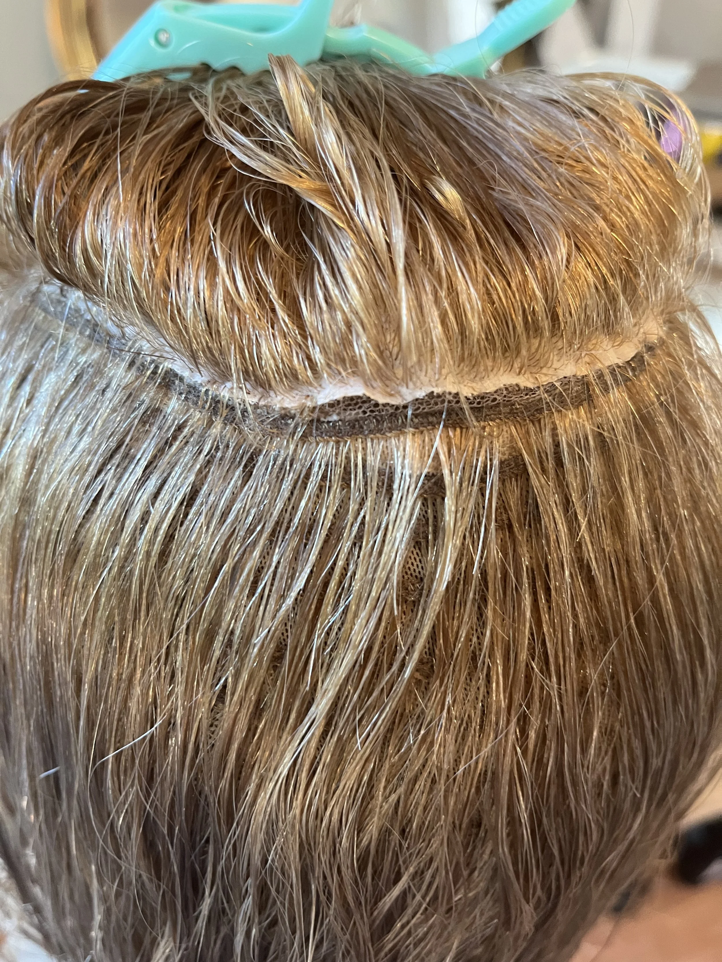 A silk top wig showing the silk edge separating from the foundation of the wig