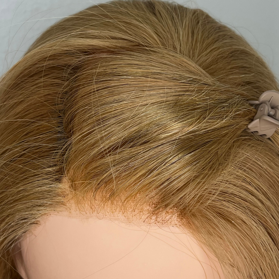 Top view of wig on mannequin head after fill in service is completed of the POV left side in temple.